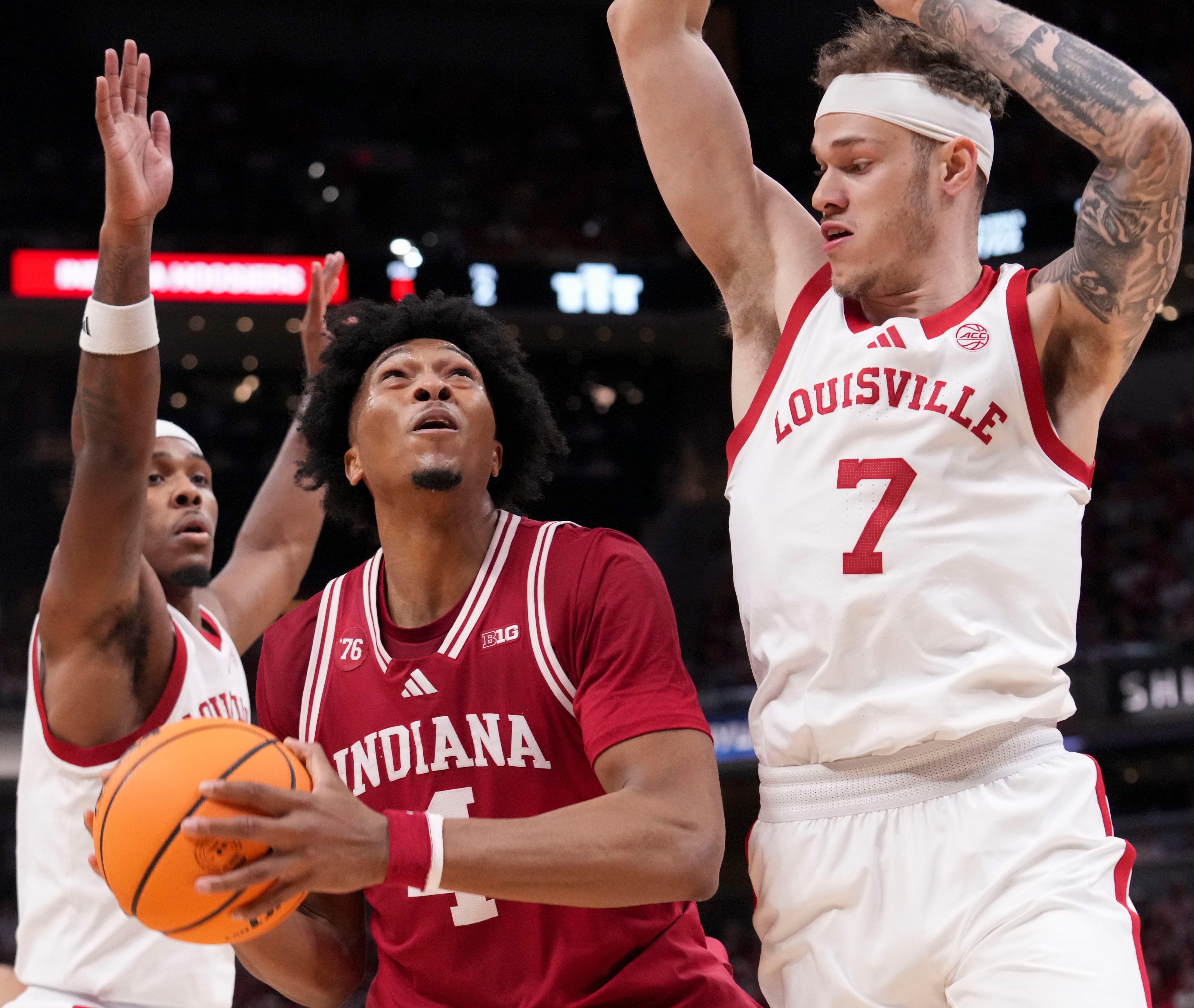Louisville Cardinals guard Ryan Conwell (3) and forward Kasean Pryor (7) defend Indiana Hoosiers forward Sam Alexis (4) as he looks to shoot during a game Saturday, Dec. 6, 2025, at Gainbridge Fieldhouse in Indianapolis. Louisville defeated Indiana 87-78.