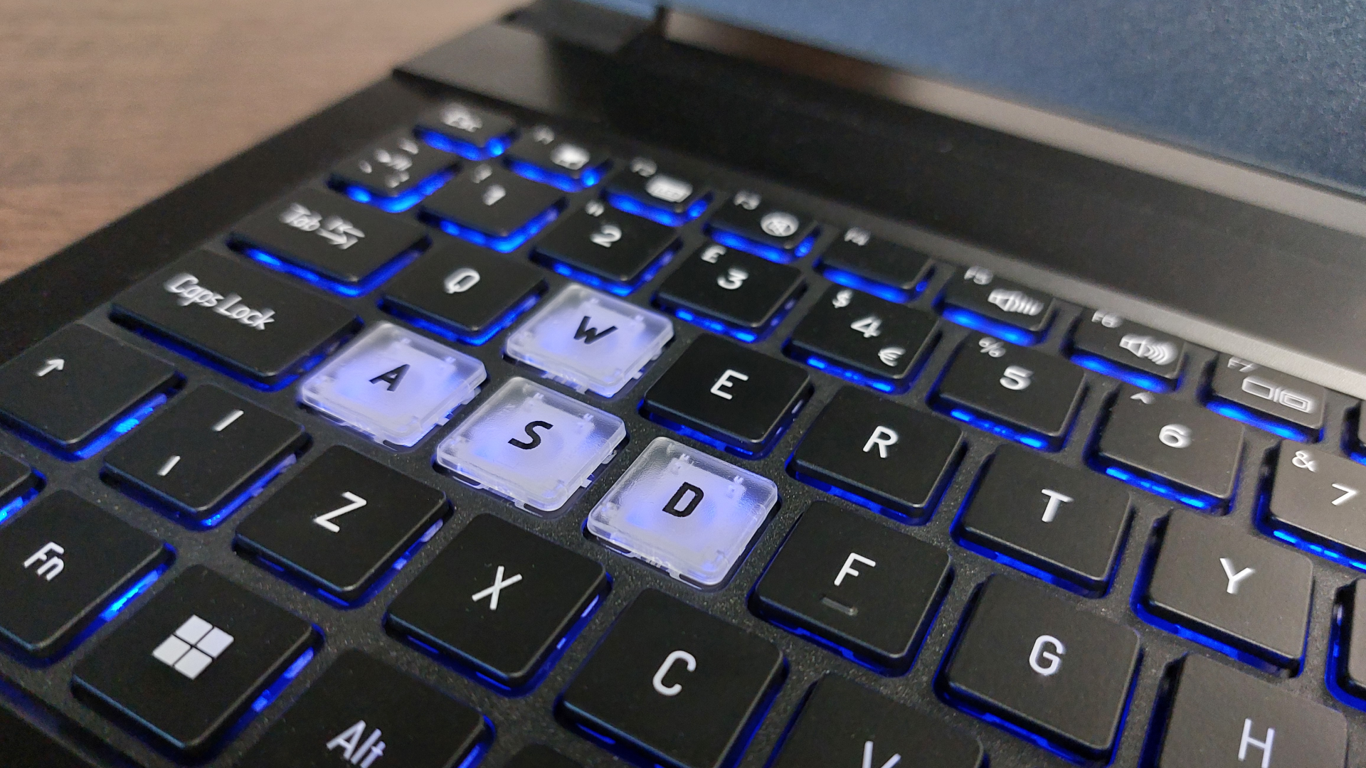 The Erazer Scout 15 E1 RTX 5050 gaming laptop is seen on a wooden desk in a brightly lit, neutral toned office.