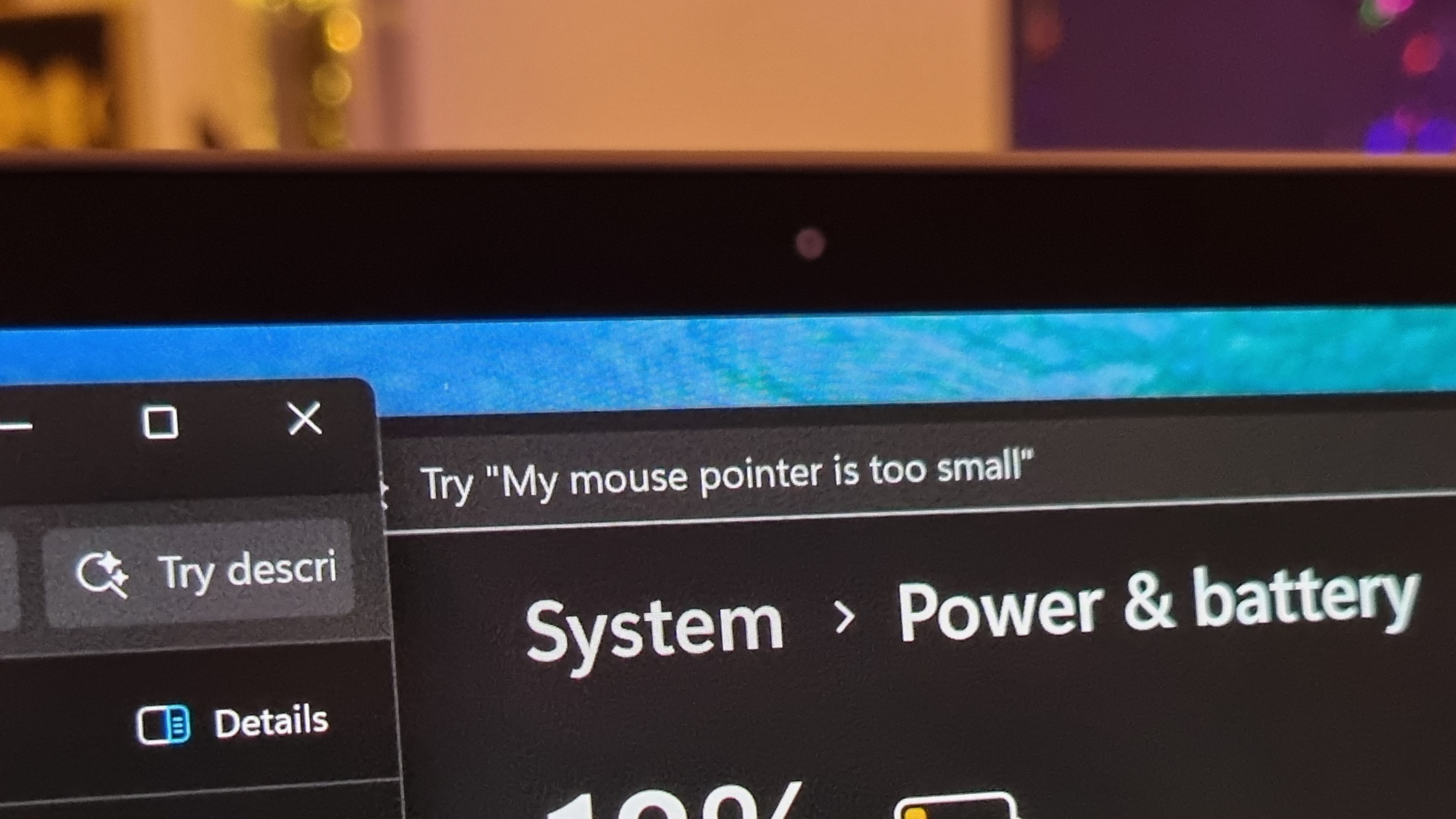 A photo of a laptop running Windows 11, with the settings menu AI prompt making fun of the size of my mouse pointer. At least, that's the way I read it.