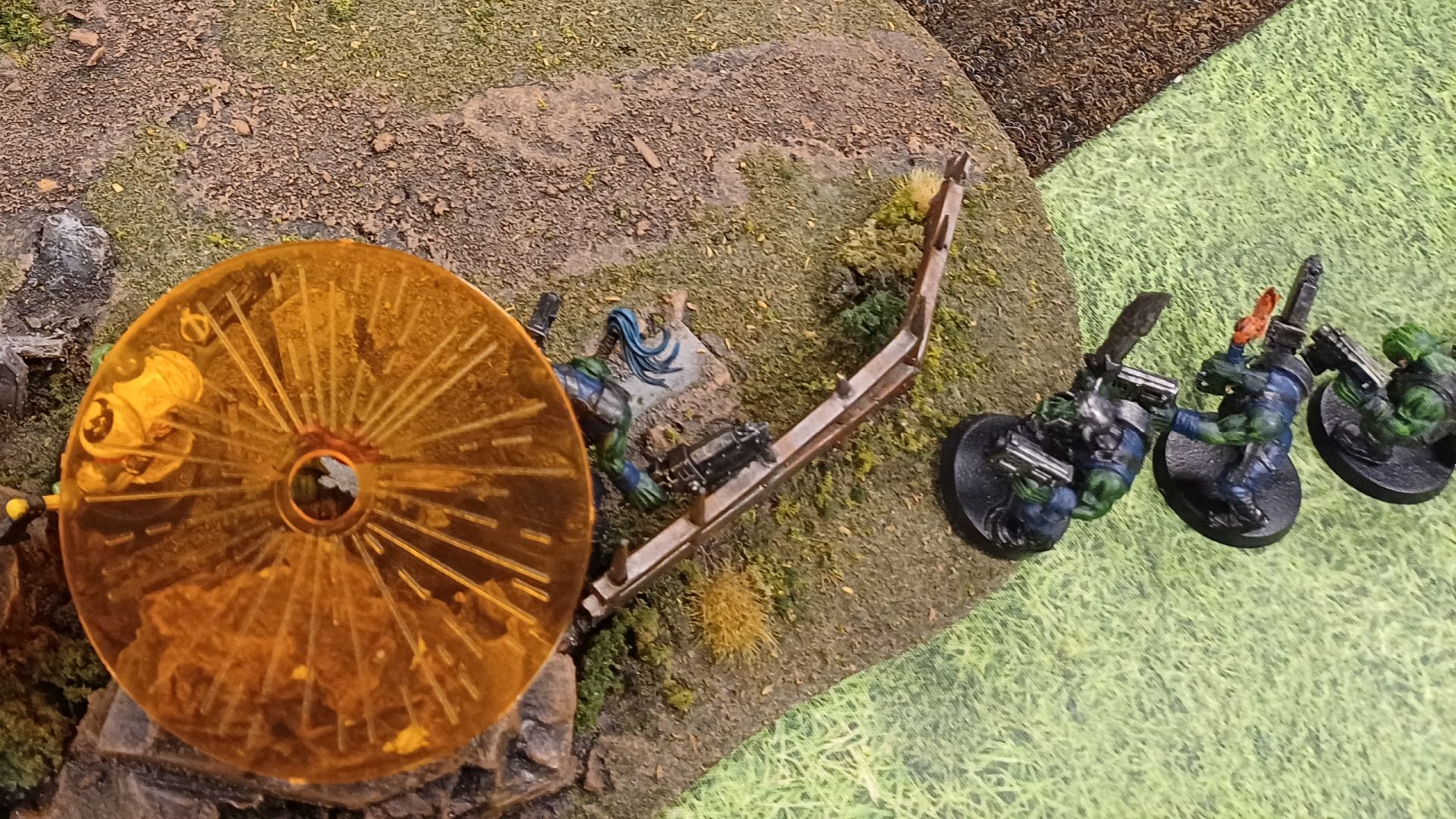 A squad of orks, three of which are covered by an orange blast template