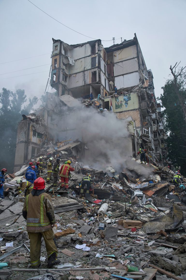 Rescuers work in a destroyed apartment building after a Russian missile attack in Kyiv, Ukraine, Thursday, July 31, 2025. (AP Photo/Efrem Lukatsky)