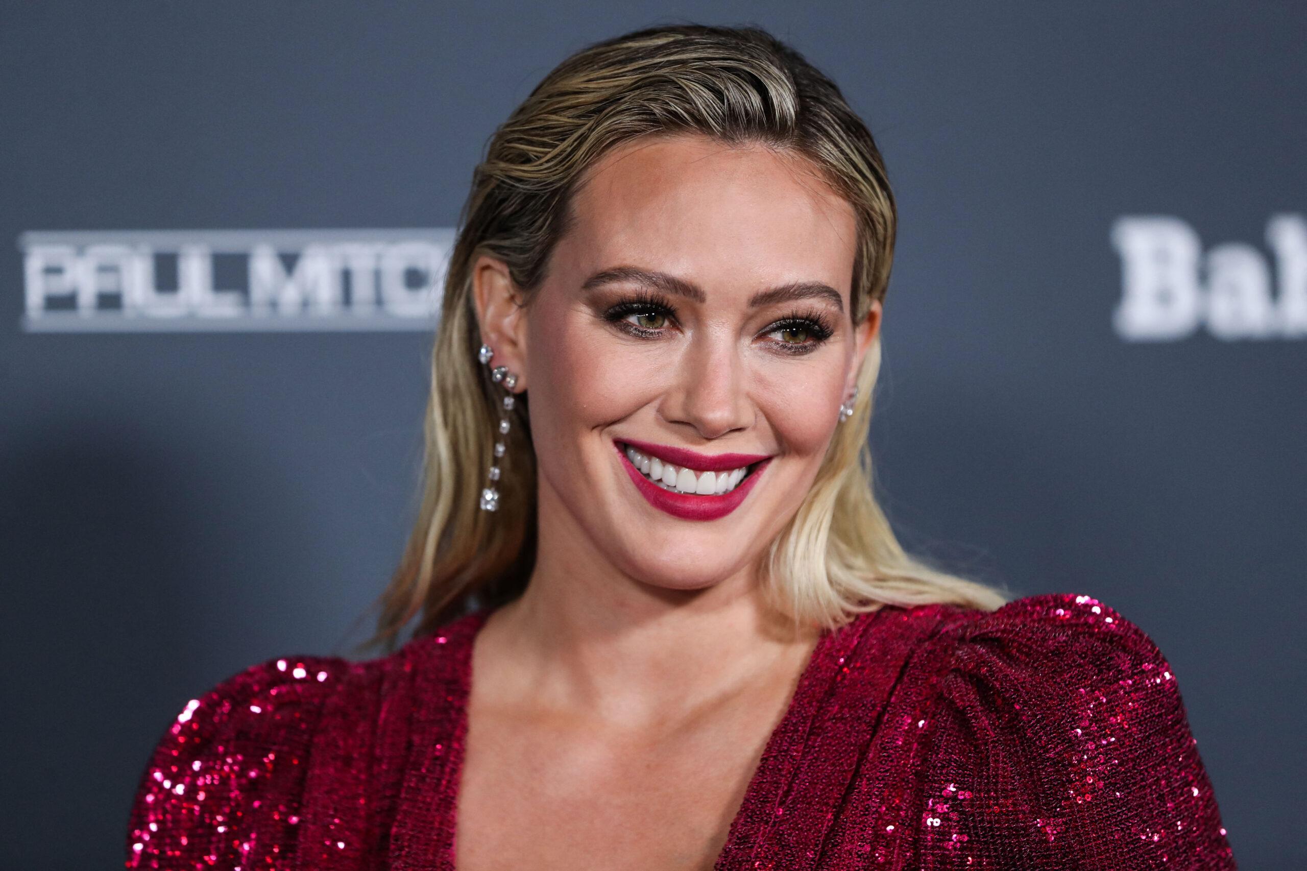 Hilary Duff wearing an Osman dress and Rahamoniv jewelry while wearing shoes and carrying a clutch by Jimmy Choo arrives at the Baby2Baby 10-Year Gala 2021