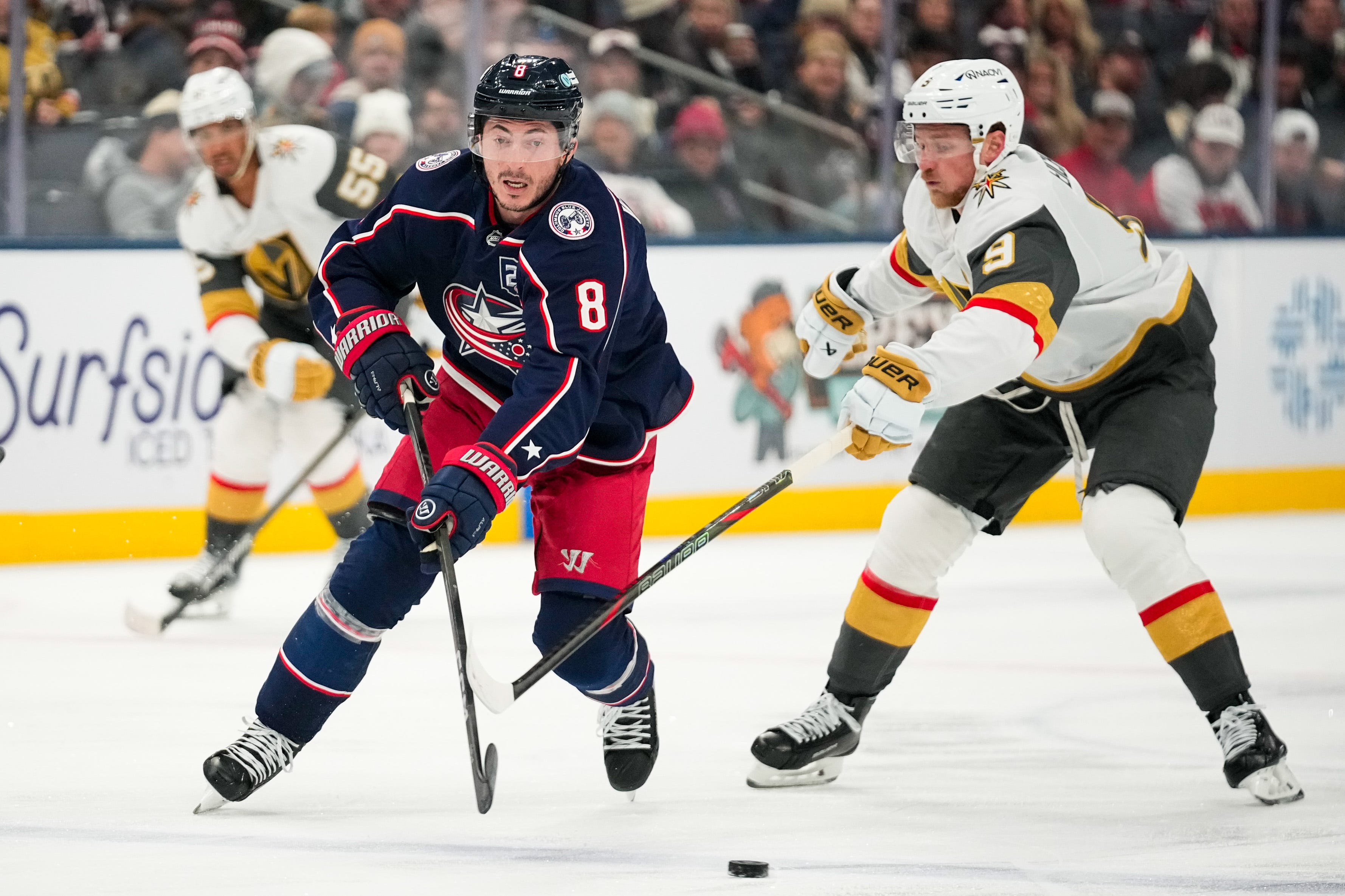 Columbus Blue Jackets defenseman Zach Werenski (8) moves the puck against Vegas Golden Knights center Jack Eichel (9) in the third period of the NHL game at Nationwide Arena on Saturday, Dec. 13, 2025 in Columbus, Ohio.
