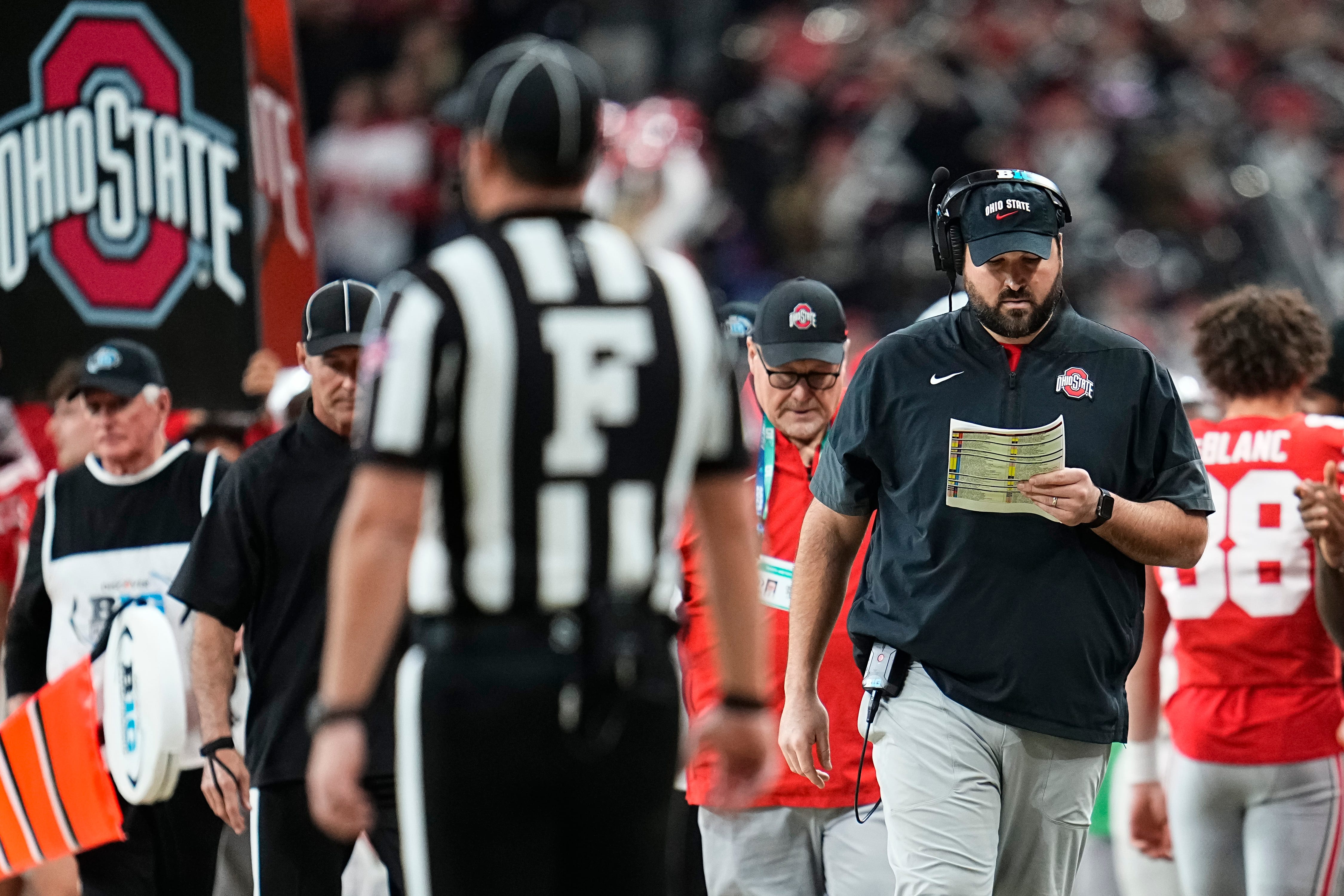 Ohio State Buckeyes offensive line coach Tyler Bowen looks at the play sheet during the Big Ten Conference championship game against the Indiana Hoosiers at Lucas Oil Stadium in Indianapolis on Dec. 6, 2025. Ohio State lost 13-10.