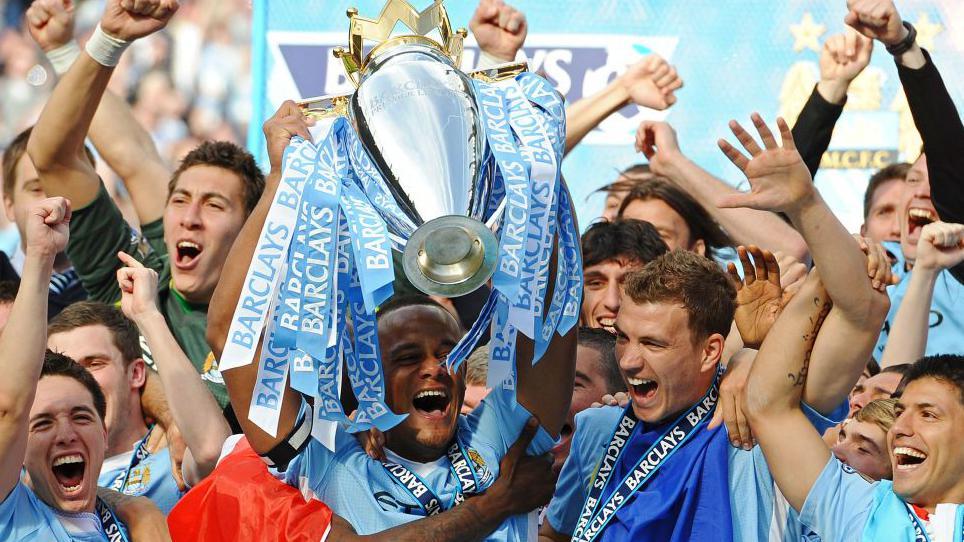 Manchester City captain Vincent Kompany lifts the Premier League trophy following the injury-time win against QPR in 2012