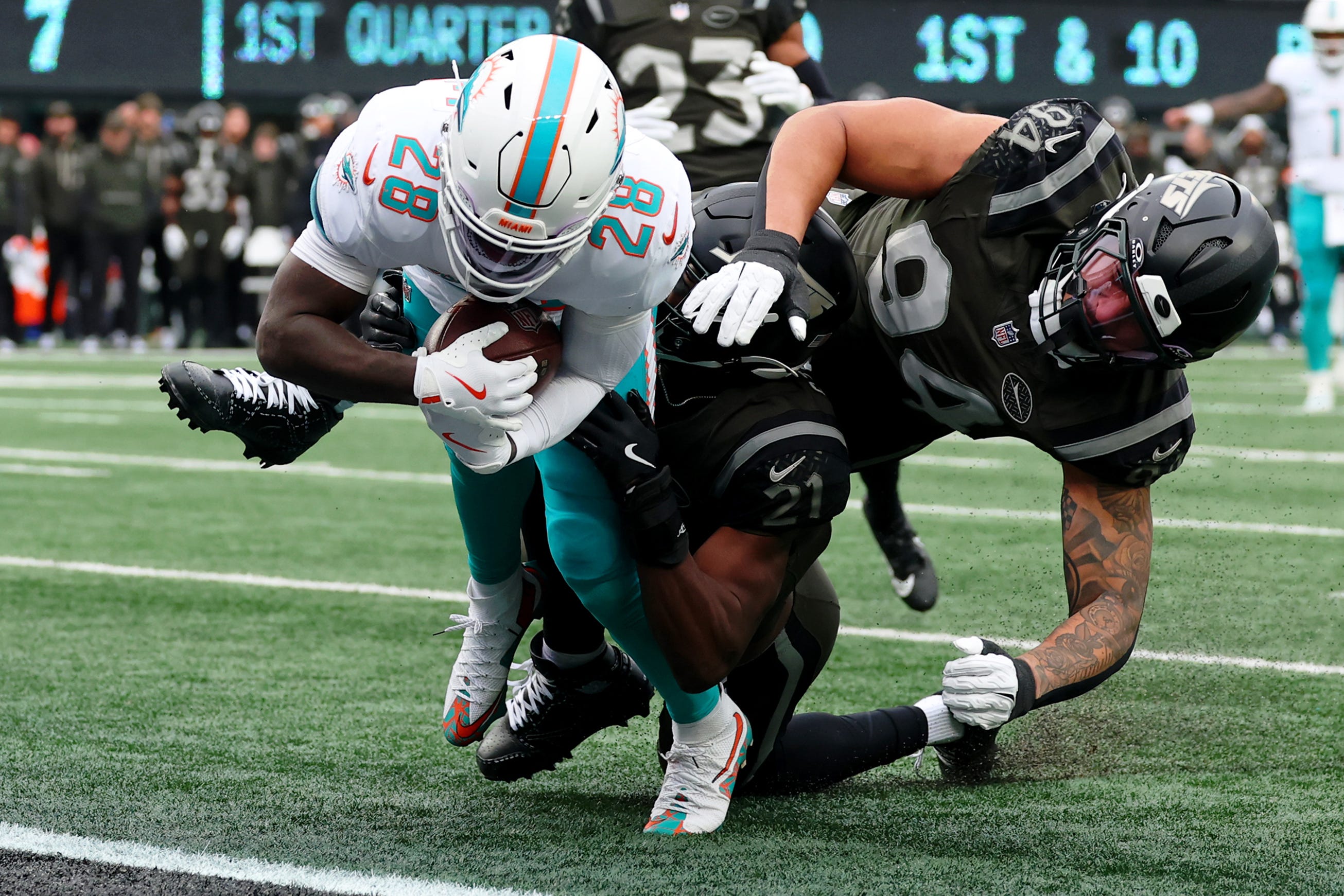 Dec 7, 2025; East Rutherford, New Jersey, USA; Miami Dolphins running back De'Von Achane (28) scores a touchdown against the New York Jets during the first half at MetLife Stadium. Mandatory Credit: Ed Mulholland-Imagn Images