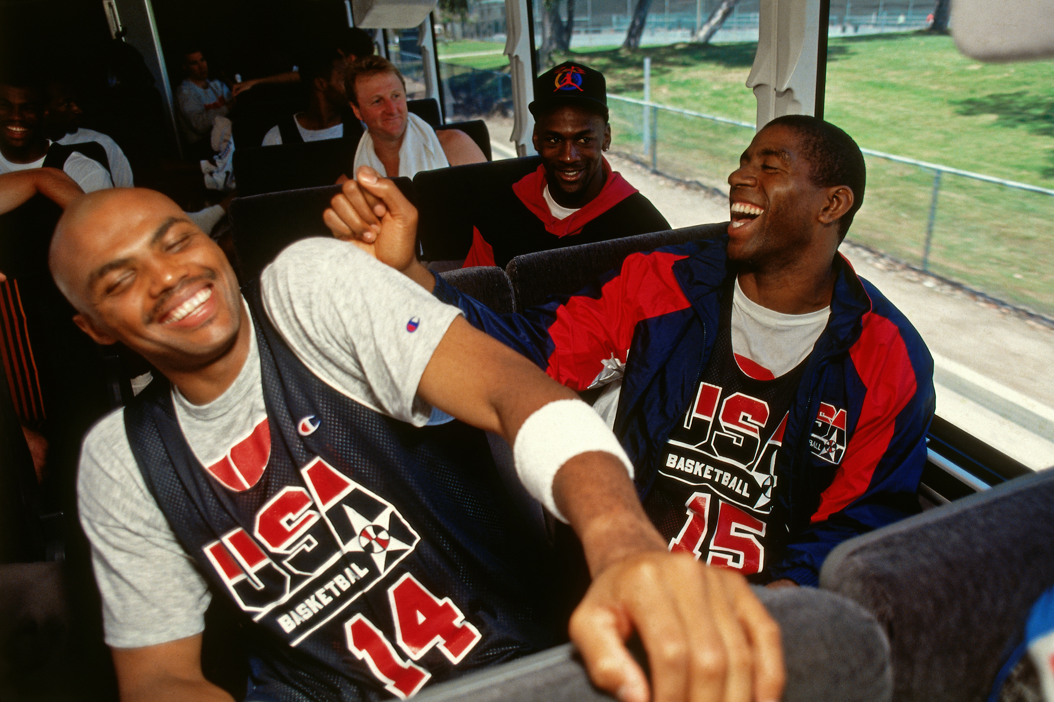BARCELONA, SPAIN - 1992: Charles Barkley #14, Michael Jordan #9, and Magic Johnson #15 of the United States talk on the team bus during the 1992 Summer Olympics in Barcelona, Spain. NOTE TO USER: User expressly acknowledges and agrees that, by downloading and/or using this photograph, user is consenting to the terms and conditions of the Getty Images License Agreement. Mandatory Copyright Notice: Copyright 1992 NBAE (Photo by Andrew D. Bernstein/NBAE via Getty Images)