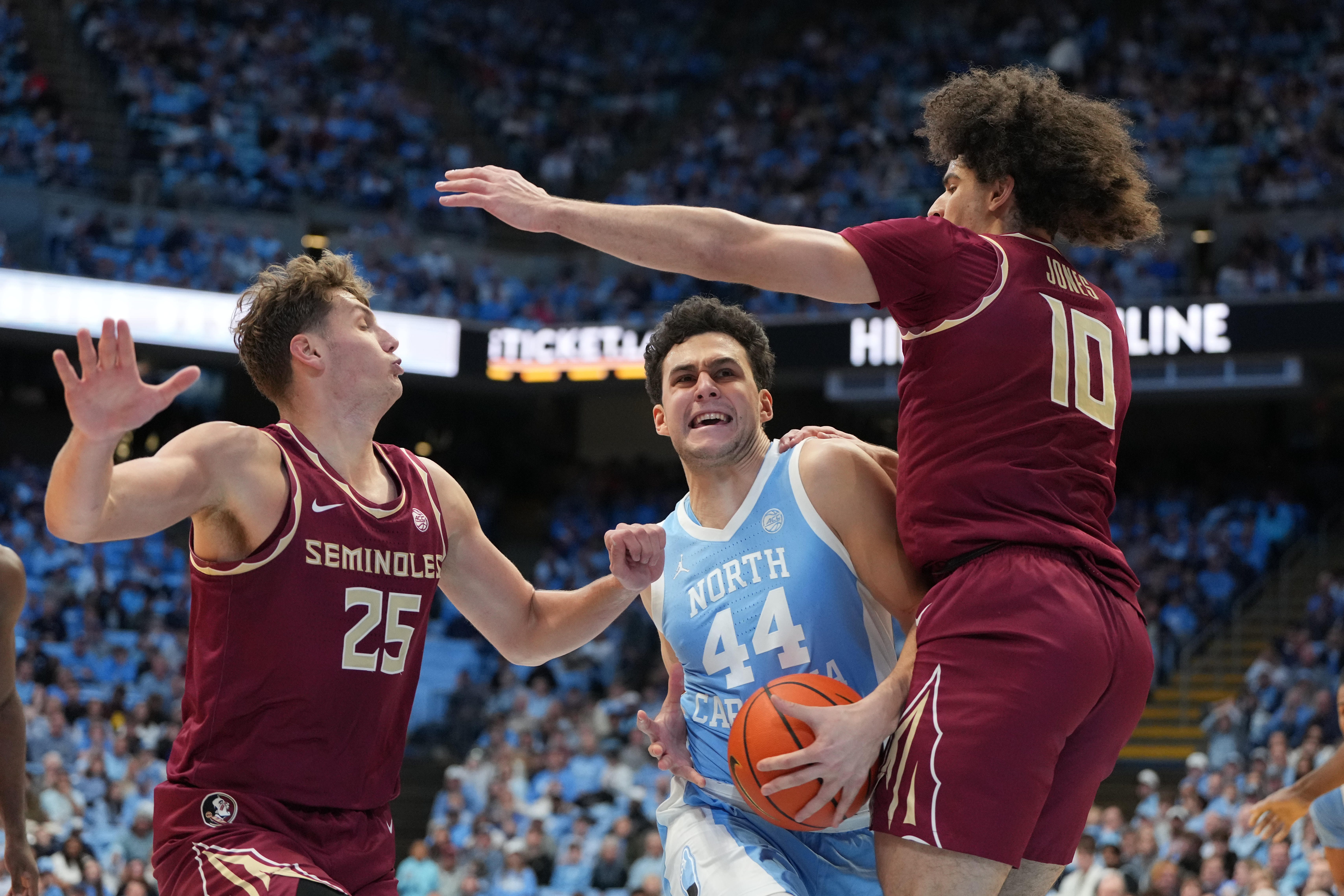 Dec 30, 2025; Chapel Hill, North Carolina, USA; North Carolina Tar Heels guard Luka Bogavac (44) with the ball as Florida State Seminoles forward Alex Steen (25) and guard Lajae Jones (10) defend in the second half at Dean E. Smith Center. Mandatory Credit: Bob Donnan-Imagn Images