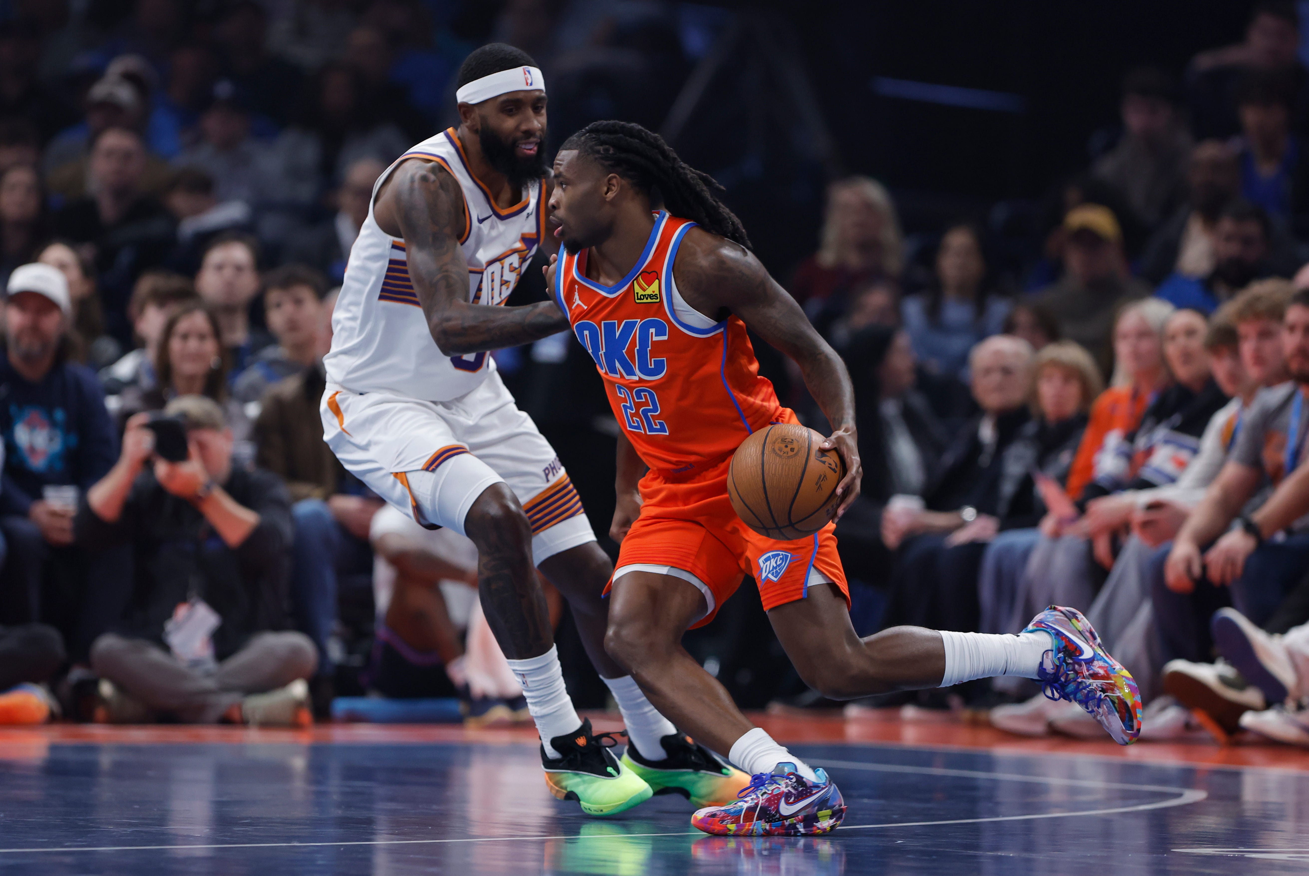 Nov 28, 2025; Oklahoma City, Oklahoma, USA; Oklahoma City Thunder guard Cason Wallace (22) moves the ball past Phoenix Suns forward Royce O'Neale (00) during the first quarter at Paycom Center. Mandatory Credit: Alonzo Adams-Imagn Images