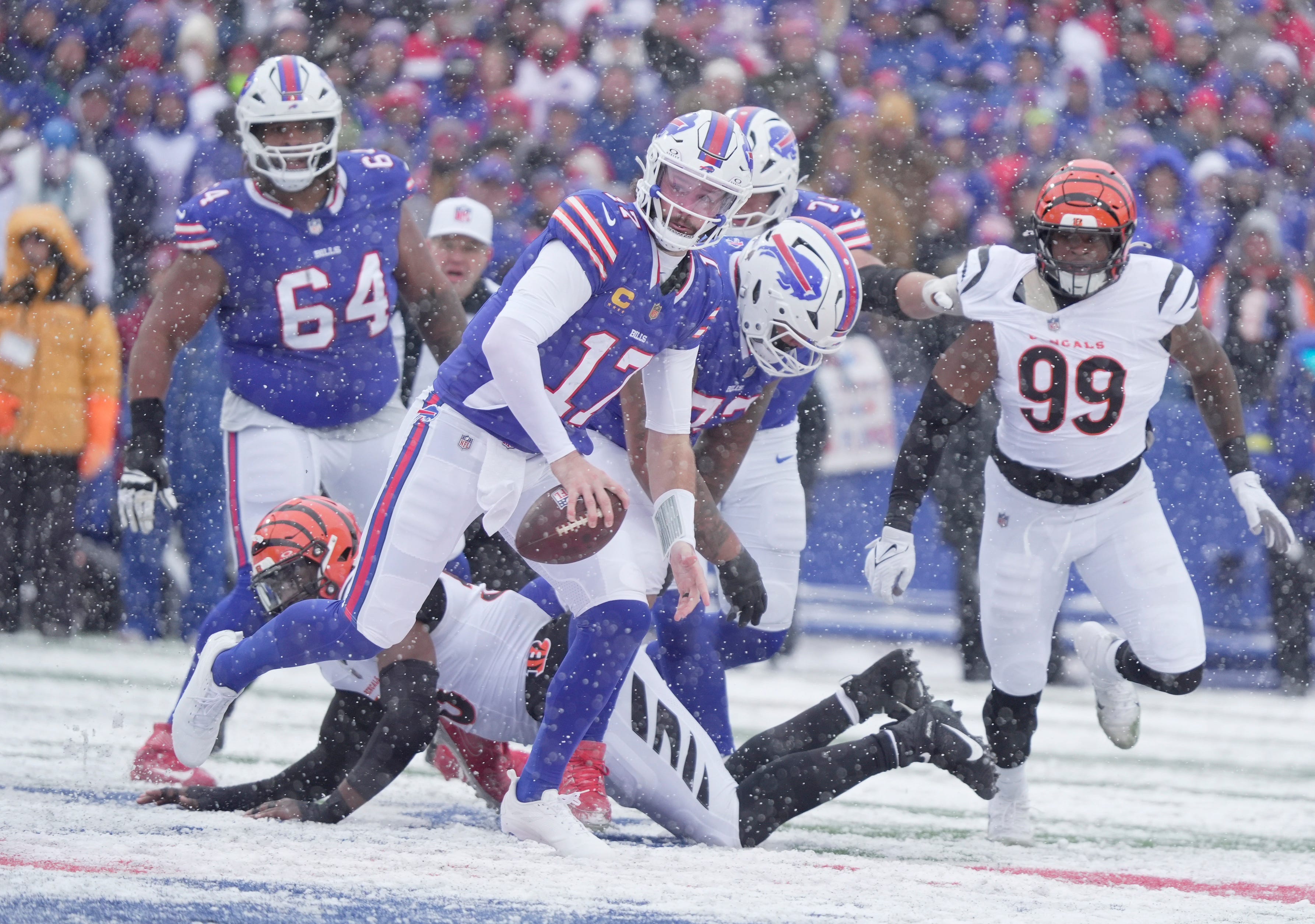 Buffalo Bills quarterback Josh Allen runs past a Bengals player looking for an open receiver to throw to during first half action at Highmark Stadium in Orchard Park on Dec. 7, 2025.