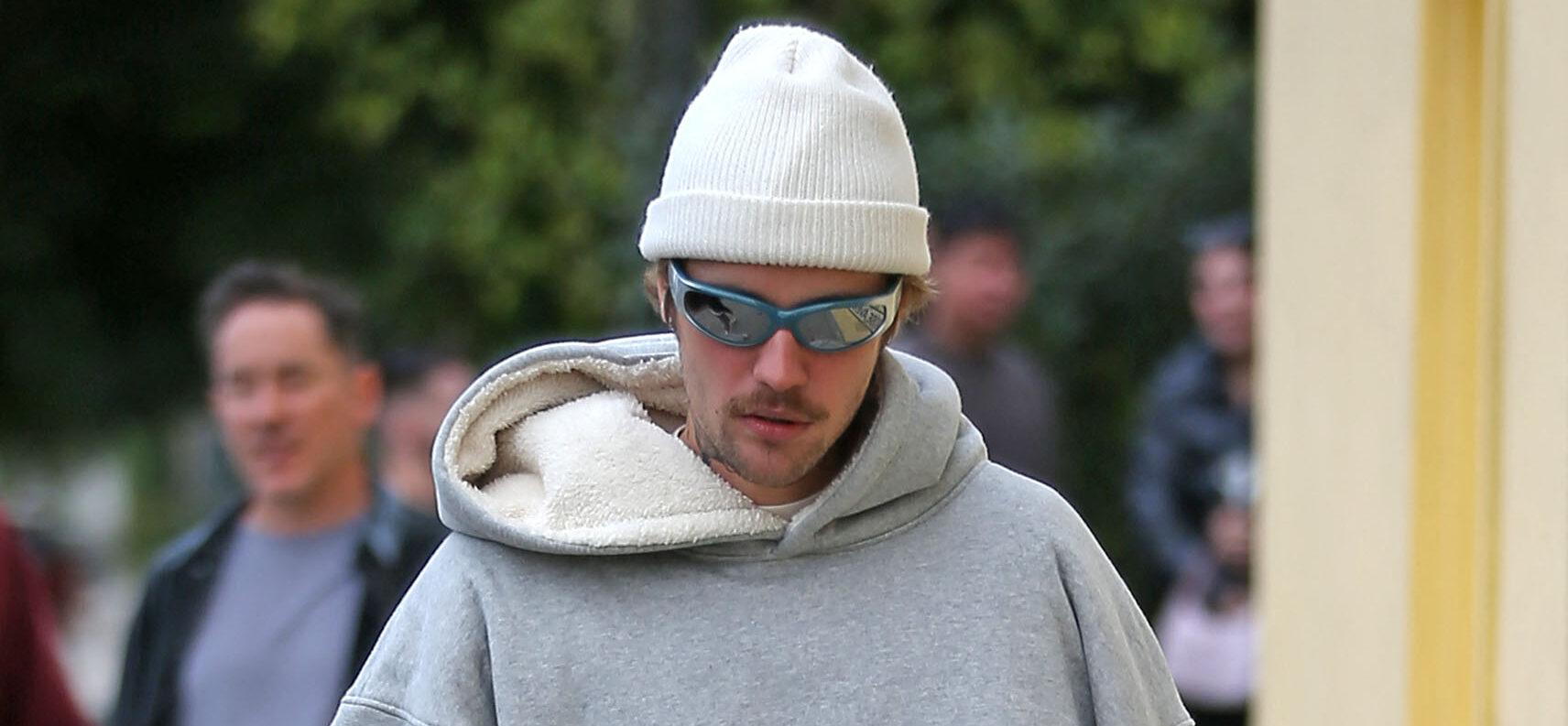 Justin Bieber carries a coffee in a strange way