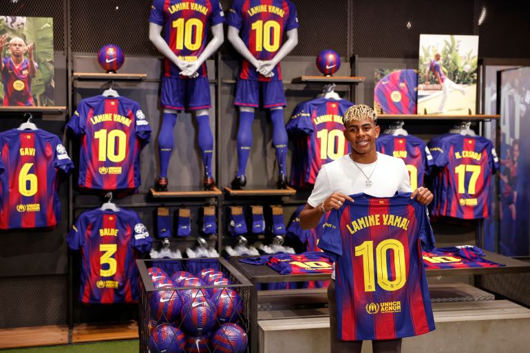 FC Barcelona player Lamine Yamal poses with his new jersey after signing a contract extension with the soccer club in Barcelona, northern Spain, Wednesday, July 16, 2025. (AP Photo/Joan Monfort)