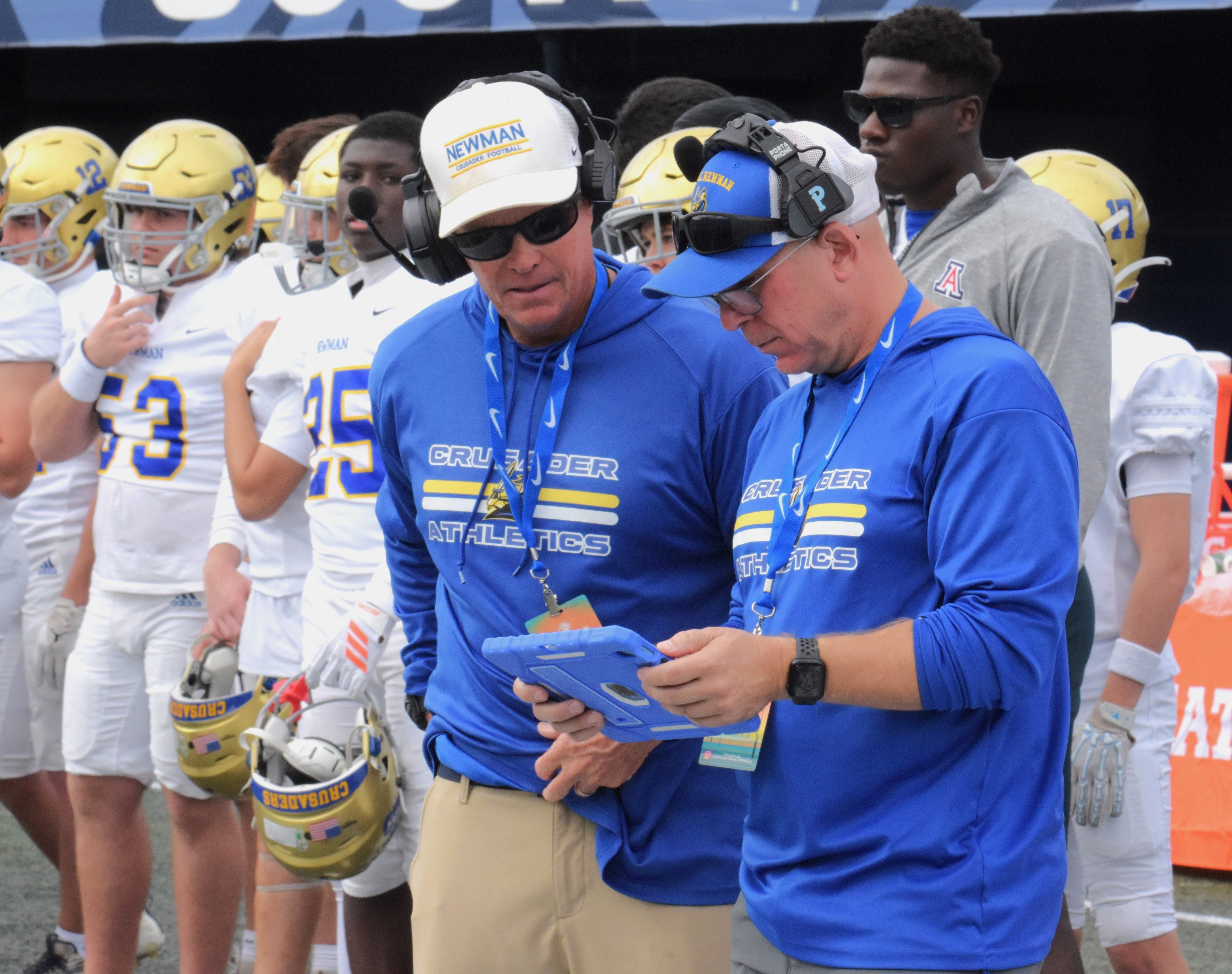 Cardinal Newman's Jack Daniels discusses strategy with his coaches during the Crusaders' state championship victory over Chaminade Madonna on Dec. 11, 2025.