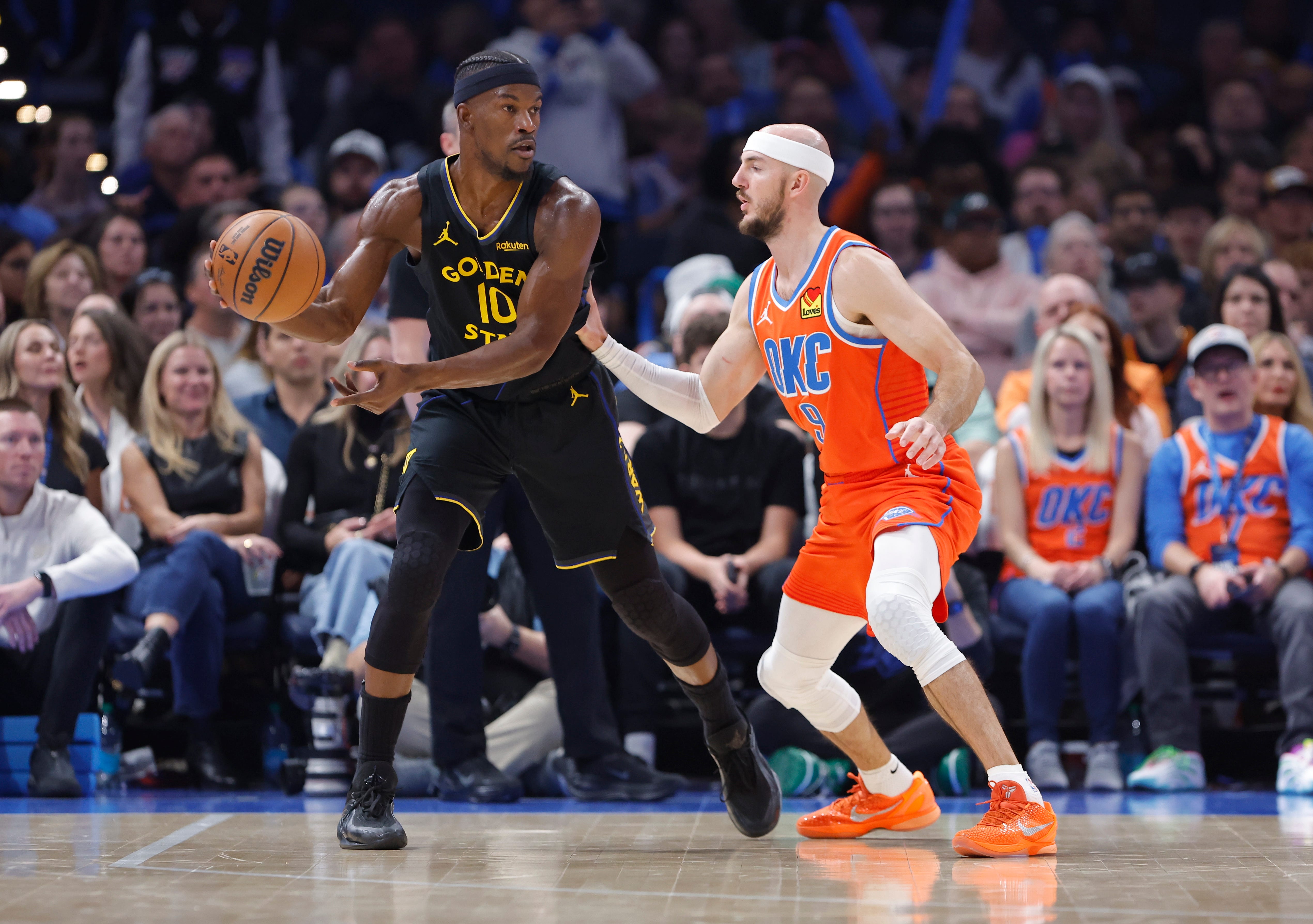 Nov 11, 2025; Oklahoma City, Oklahoma, USA; Golden State Warriors forward Jimmy Butler III (10) moves the ball as Oklahoma City Thunder guard Alex Caruso (9) defends during the second quarter at Paycom Center. Mandatory Credit: Alonzo Adams-Imagn Images