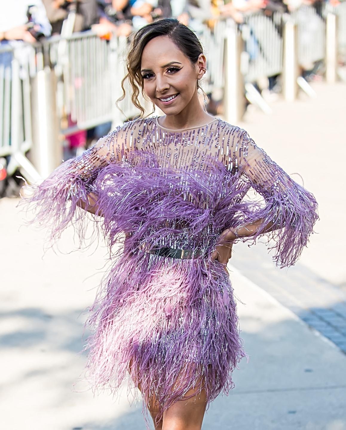 Lilliana Vazquez posing on the red carpet in a purple dress. 