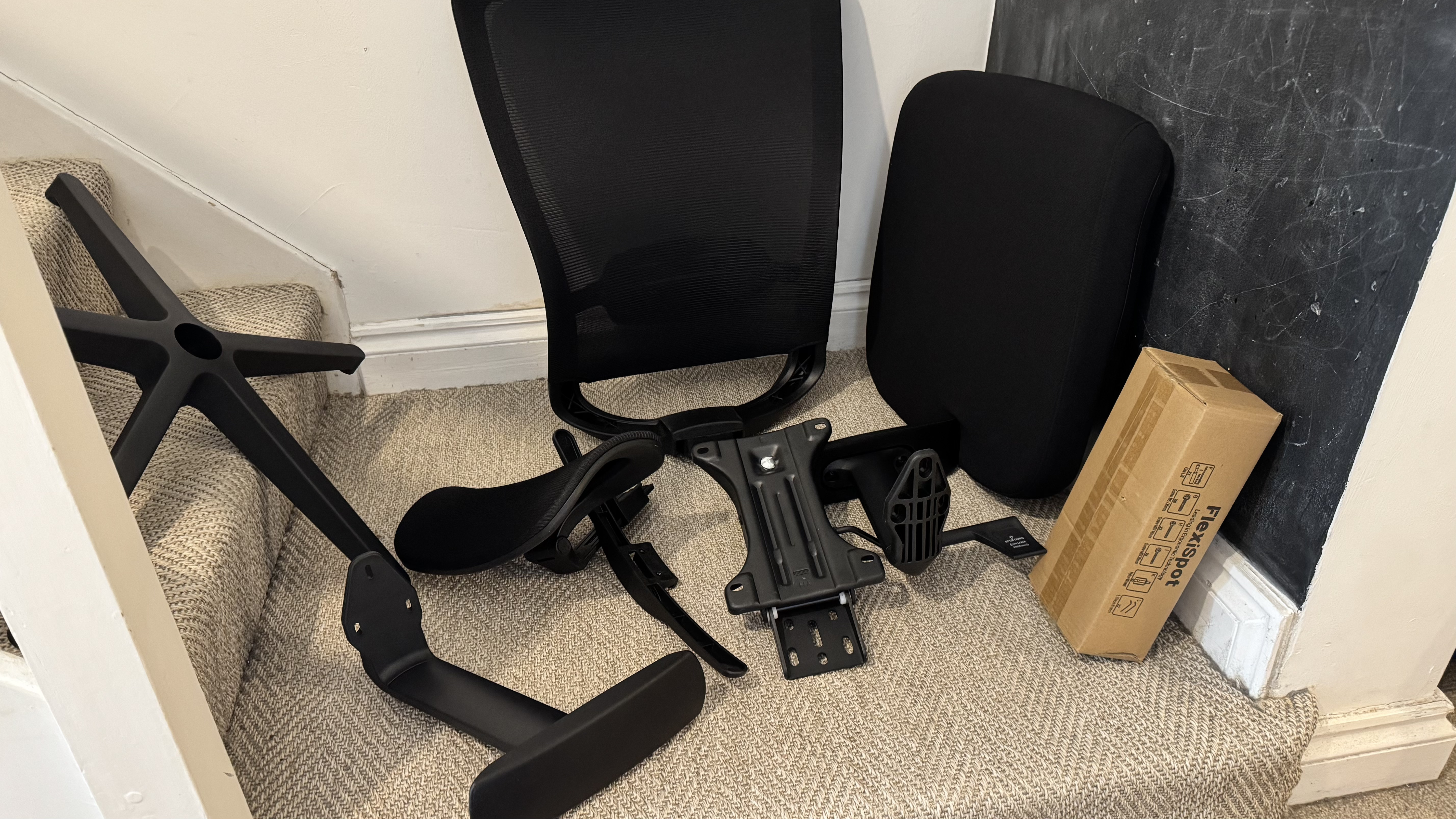 Flexispot OC3 office chair parts on the floor (in black)