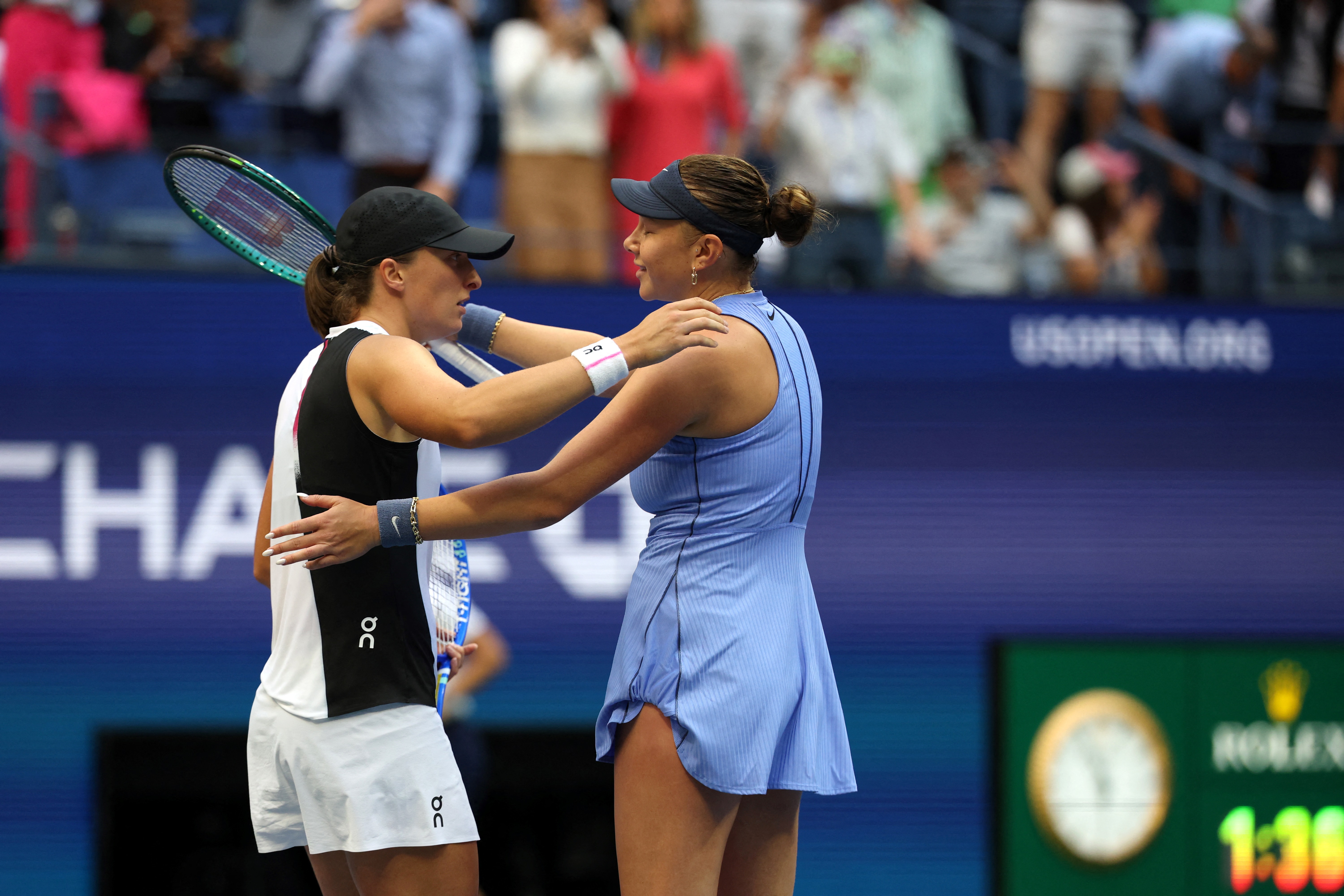 USA's Amanda Anisimova (R) and Poland's Iga Swiatek hug after Anisimova won their women's singles quarterfinal tennis match on day eleven of the US Open tennis tournament at the USTA Billie Jean King National Tennis Center in New York City on September 3, 2025. (Photo by TIMOTHY A. CLARY / AFP)