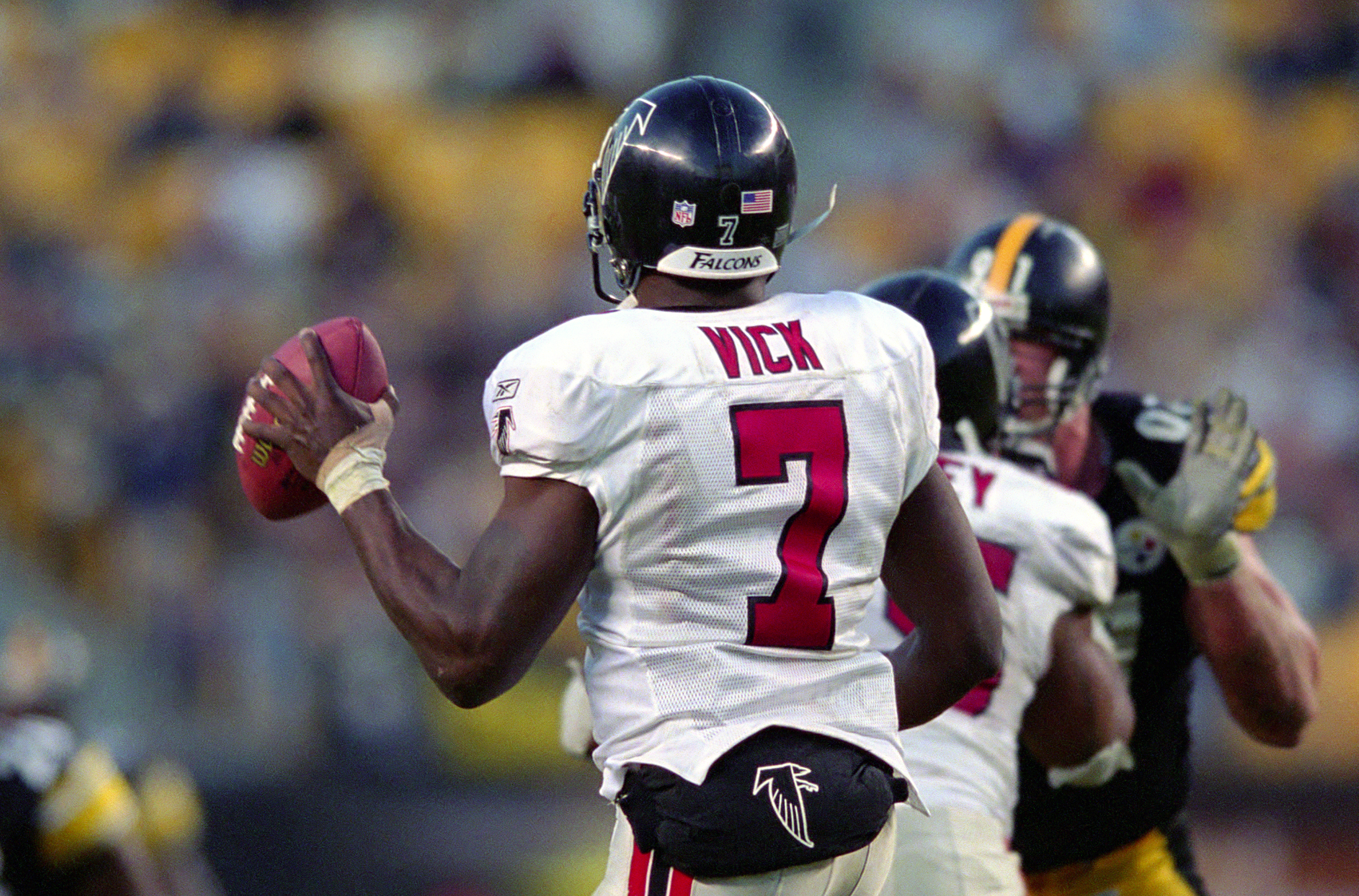 PITTSBURGH, PA - NOVEMBER 10: A view of the name and number appearing on the uniform jersey of quarterback Michael Vick #7 of the Atlanta Falcons as Vick holds the football as he looks to pass during a game against the Pittsburgh Steelers at Heinz Field on November 10, 2002 in Pittsburgh, Pennsylvania. The Steelers and Falcons tied 34-34. (Photo by George Gojkovich/Getty Images)