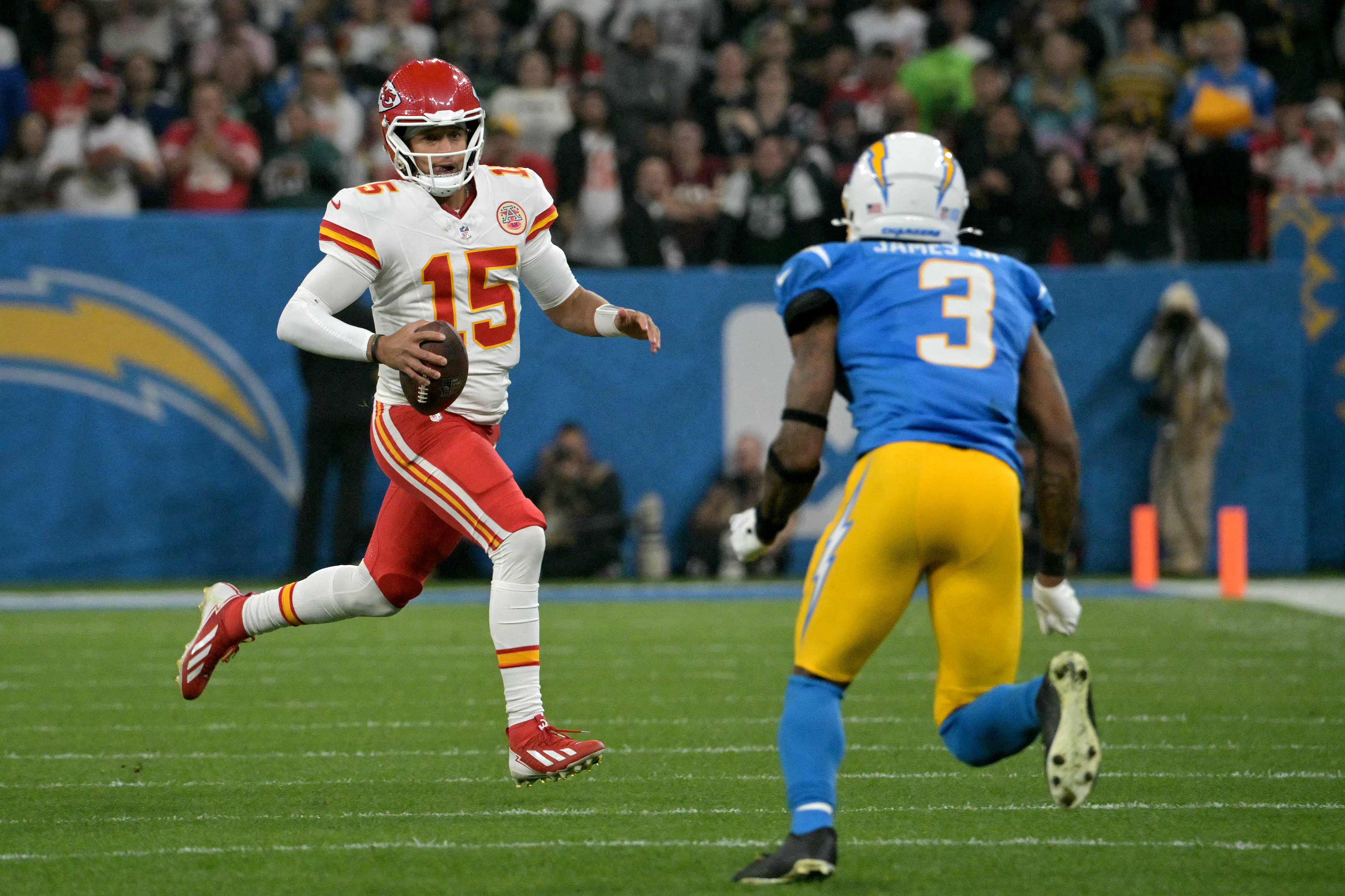 Kansas City Chiefs' quarterback #15 Patrick Mahomes runs with the ball next to Los Angeles Chargers' safety #3 Derwin James during the NFL game between the Kansas City Chiefs and Los Angeles Chargers at the Neo Quimica Arena Stadium in Sao Paulo, Brazil, on September 5, 2025. (Photo by NELSON ALMEIDA / AFP) (Photo by NELSON ALMEIDA/AFP via Getty Images)