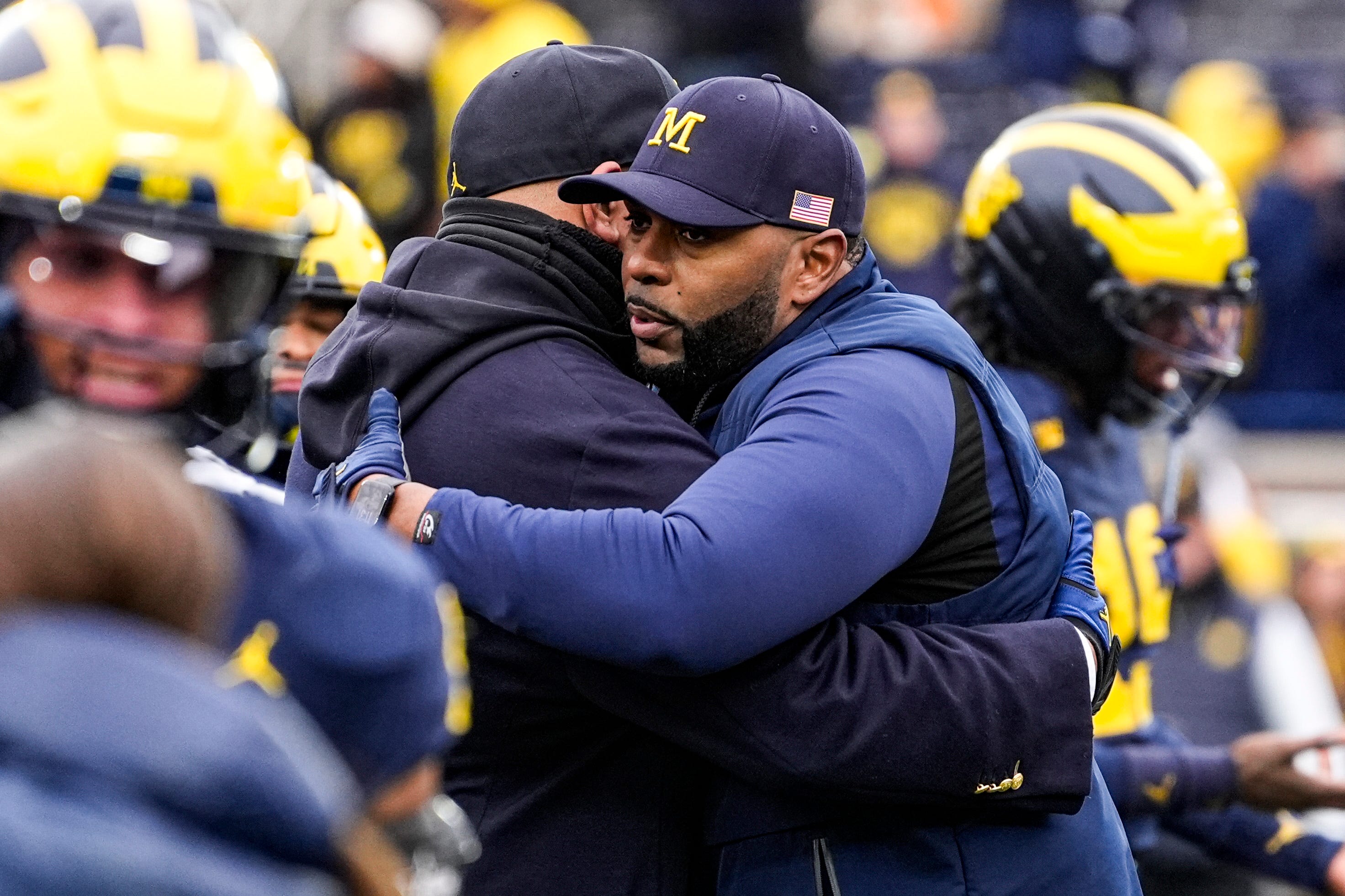Michigan head coach Sherrone Moore hugs athletic director Warde Manuel during warmup at Michigan Stadium in Ann Arbor on Saturday, Nov. 29, 2025.