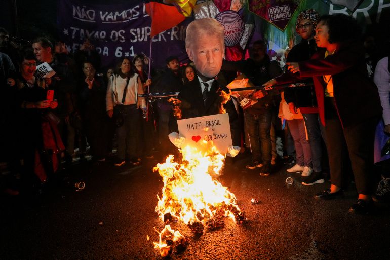 Demonstrators gather as they burn an effigy depicting U.S. President Donald Trump and U.S. flag during a protest against U.S. President Donald Trump's announcement of 50% tariffs on Brazilian products, in Sao Paulo, Brazil July 10, 2025. REUTERS/Alexandre Meneghini
