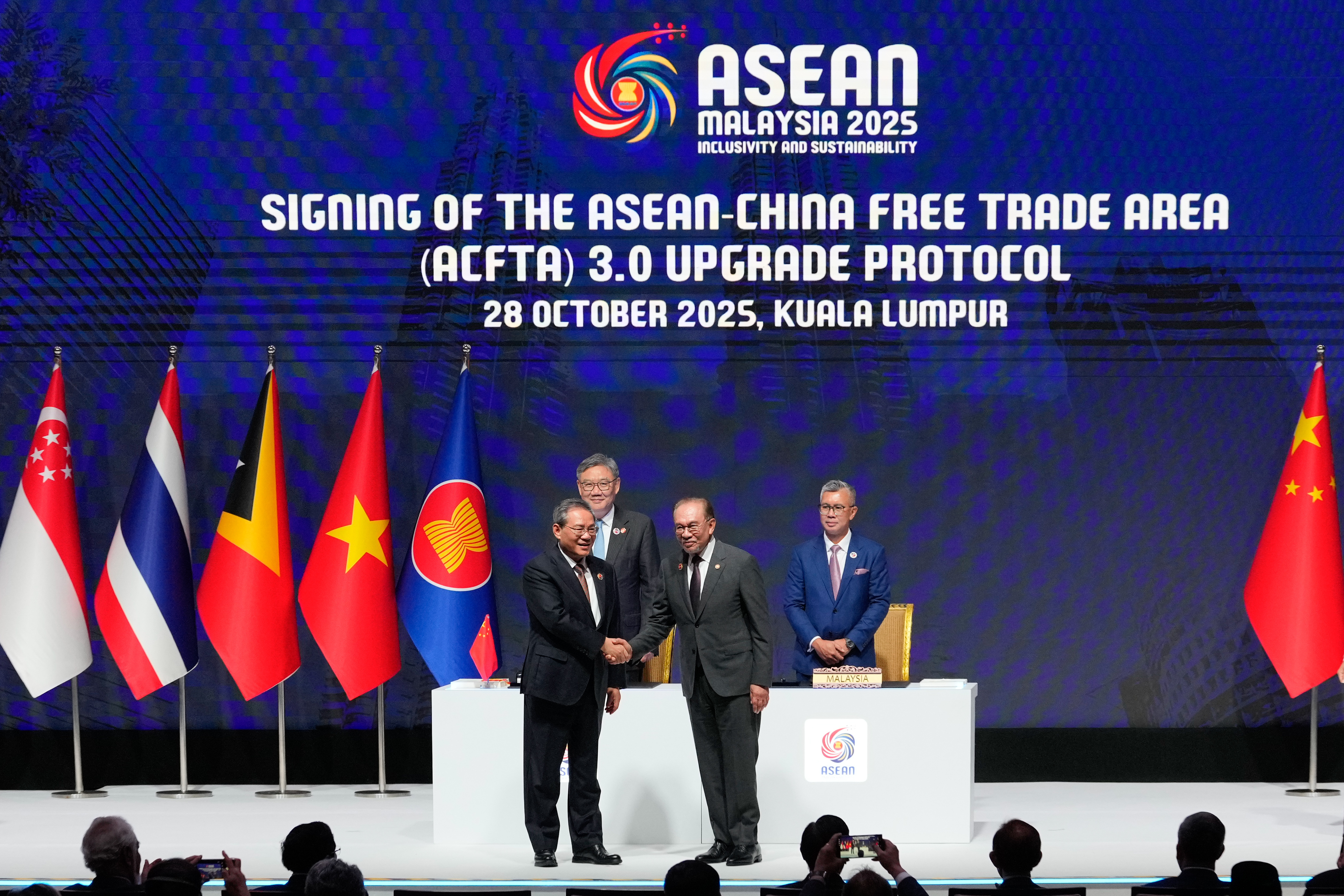 China's Premier Li Qiang, front left, and Malaysia's Prime Minister Anwar Ibrahim, front right, shake hands after witnessing the signing ceremony for the ASEAN-China Free Trade Area 3.0 in Kuala Lumpur, Malaysia, Tuesday, Oct. 28, 2025. (AP Photo/Vincent Thian)