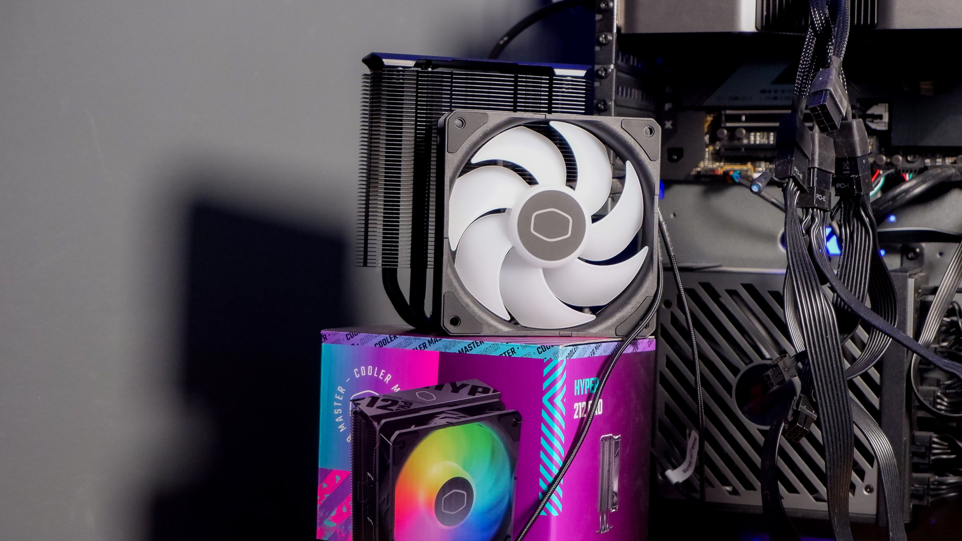 A Cooler Master Hyper 212 Pro air cooler with its packaging and installed on a gaming PC.