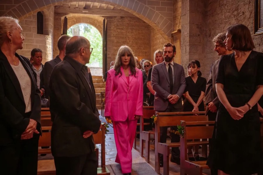 Isabella Adjani wears a pink suit at a funeral in Under a Dark Sun