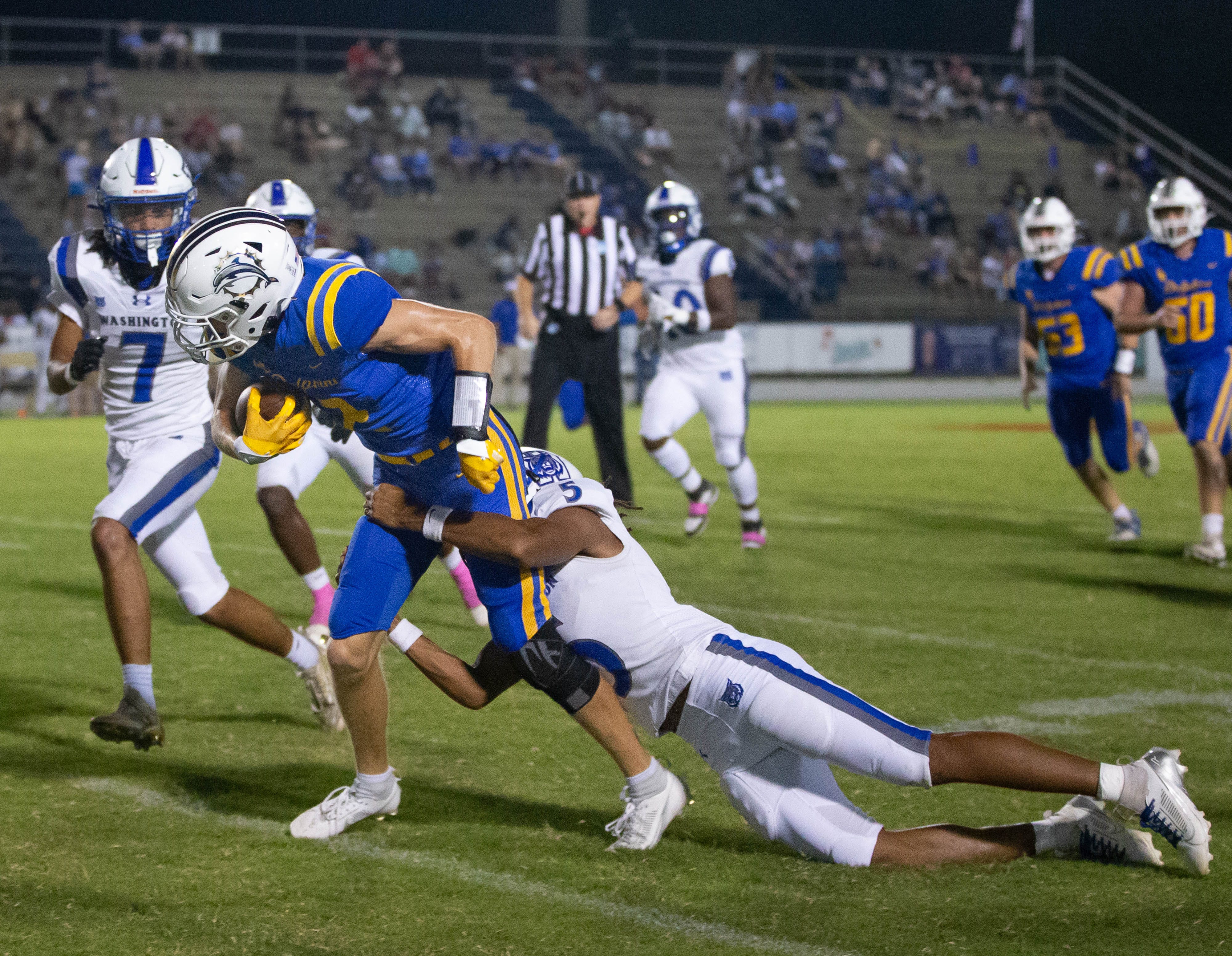Booker T. Washington's Josiah Brown (5) takes down Denver Boyett (2) but not before he picks up the first down during the Booker T. Washington vs Gulf Breeze football game at Gulf Breeze High School on Friday, Sept. 20, 2024.