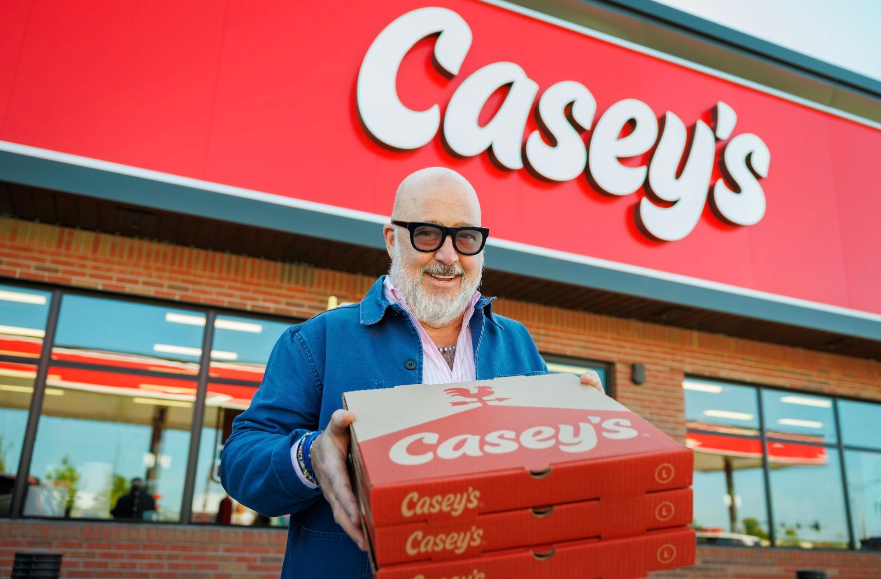 Andrew Zimmern holding Casey's pizza boxes
