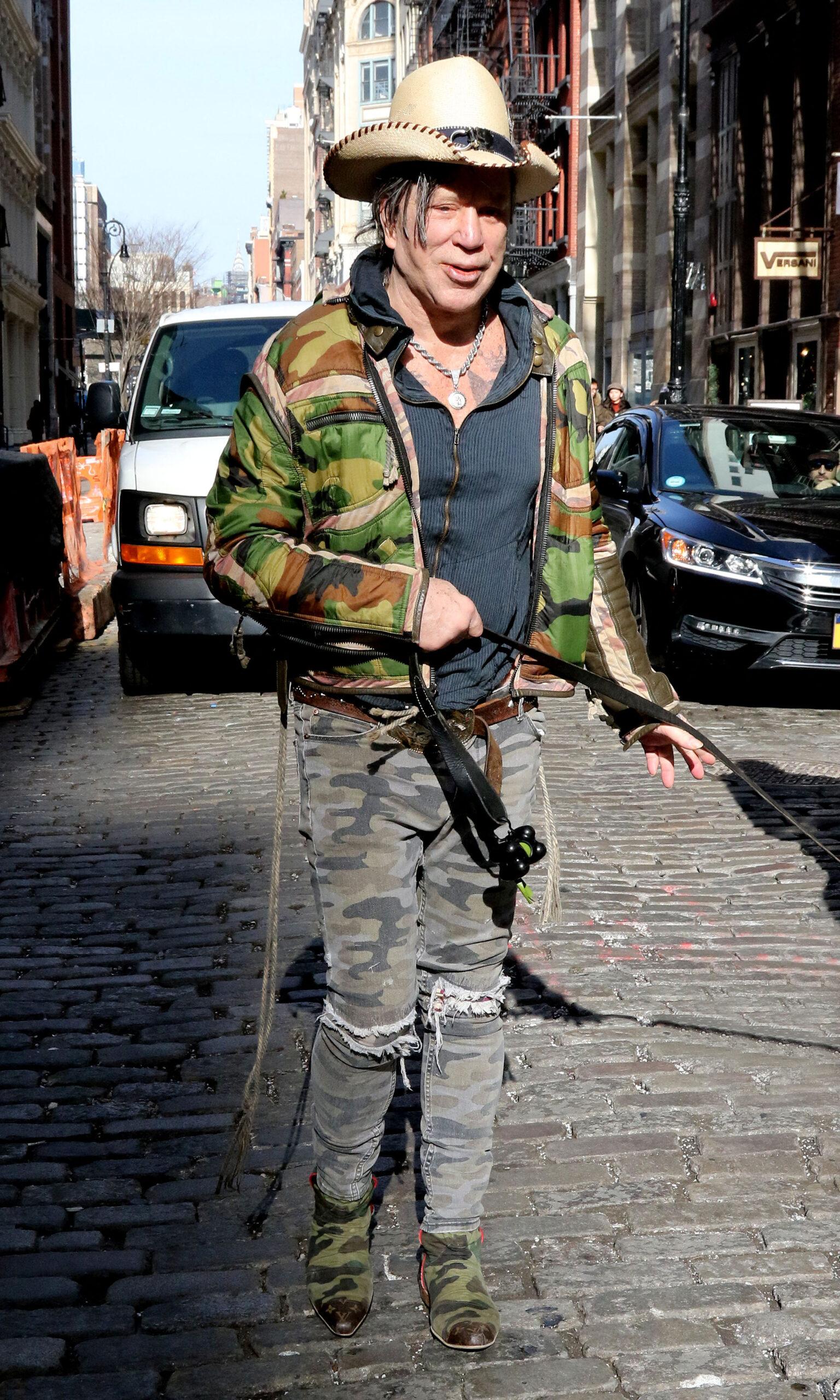 Mickey Rourke is all smiles as he jokes around with fan and carries his dog in New York City
