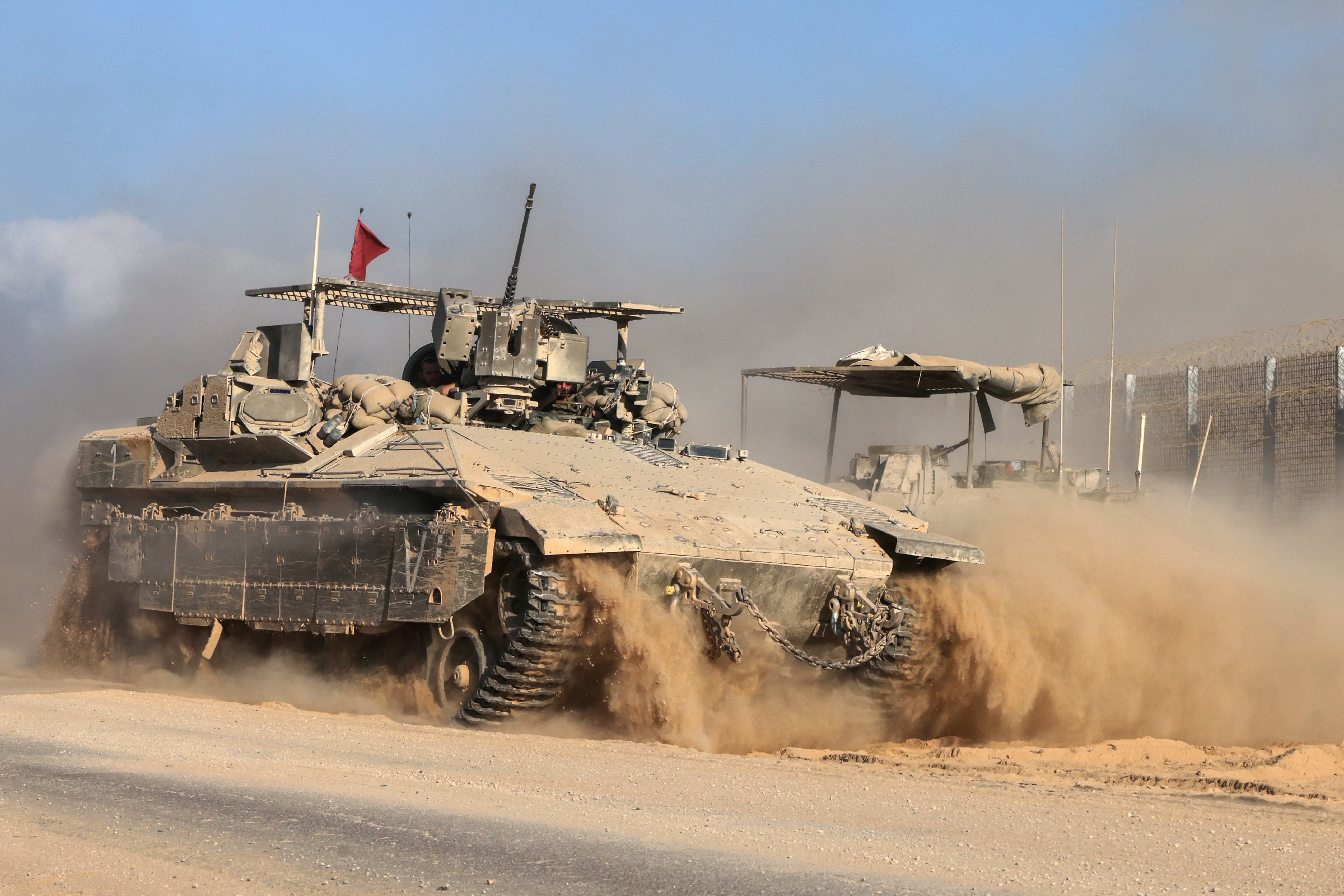 This picture taken from a position at Israel's border with the Gaza Strip shows Israeli military vehicles by the border fence in the besieged Palestinian territory on September 16, 2025.