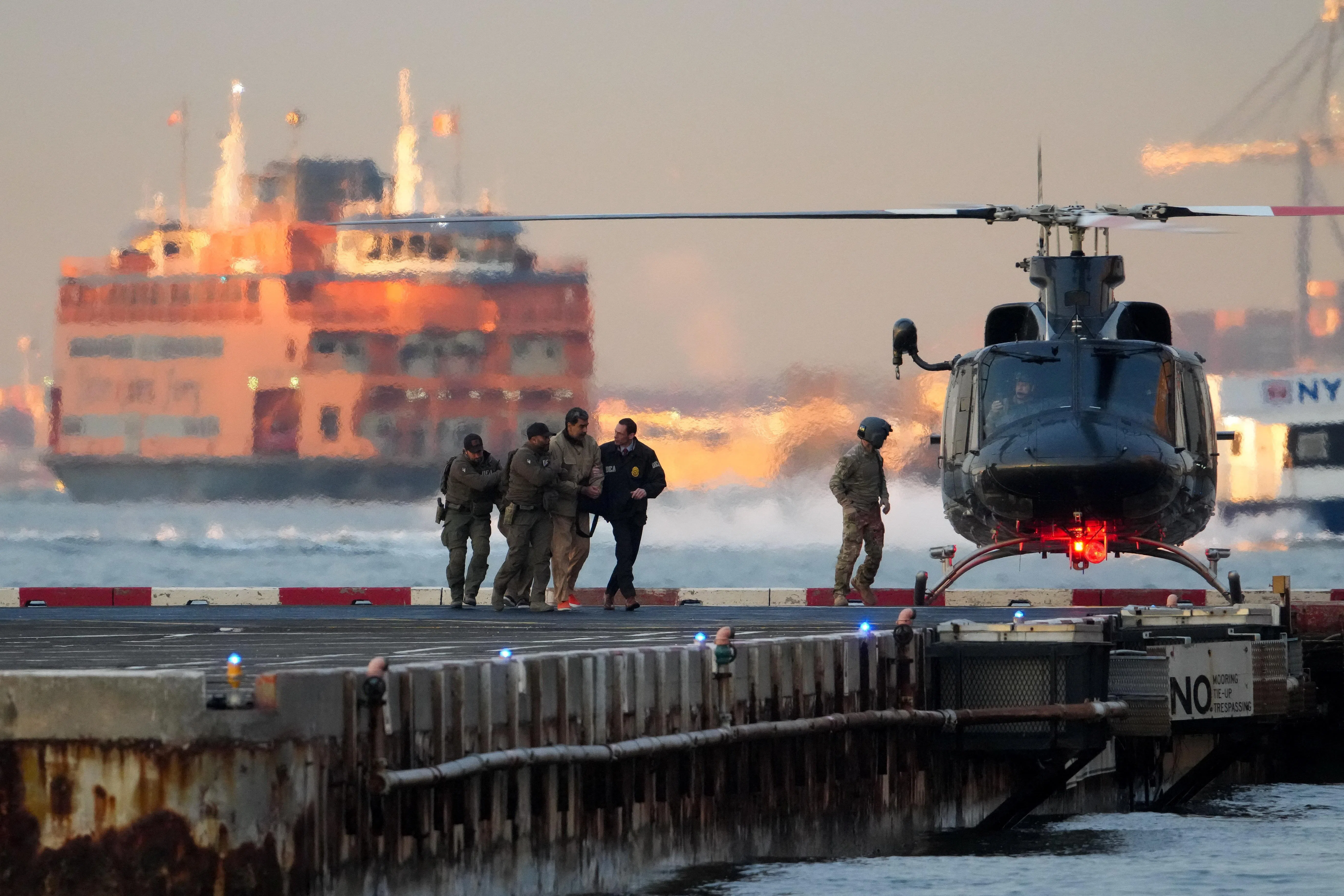 1月5日，执法人员将被捕的委内瑞拉总统马杜罗从曼哈顿下城直升机场的直升机上押下，他将被送往曼哈顿美国联邦法院出庭。（路透社）
