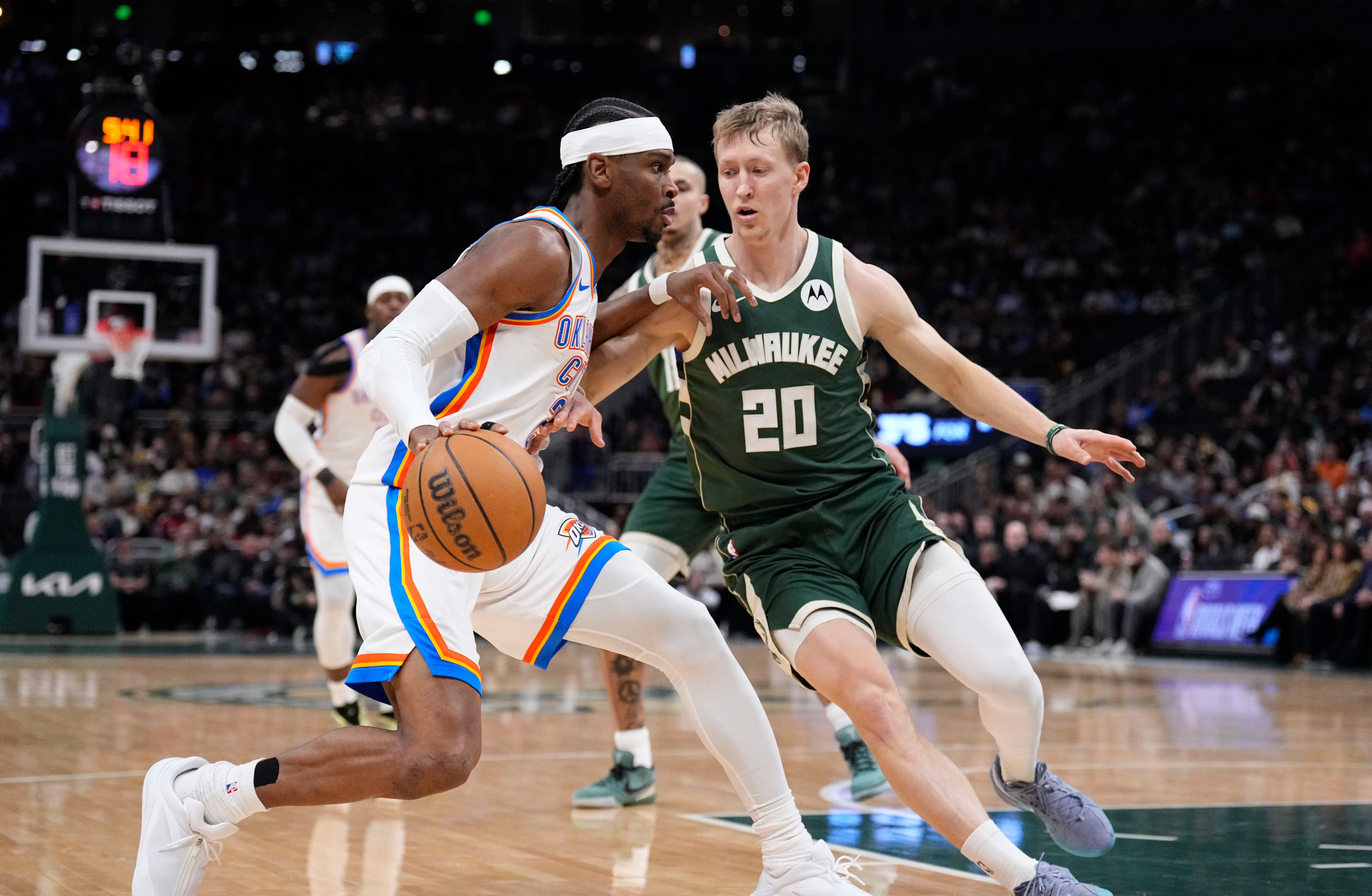 Jan 21, 2026; Milwaukee, Wisconsin, USA; Oklahoma City Thunder guard Shai Gilgeous-Alexander (2) drives to the basket against Milwaukee Bucks guard AJ Green (20) in the first half at Fiserv Forum. Mandatory Credit: Michael McLoone-Imagn Images