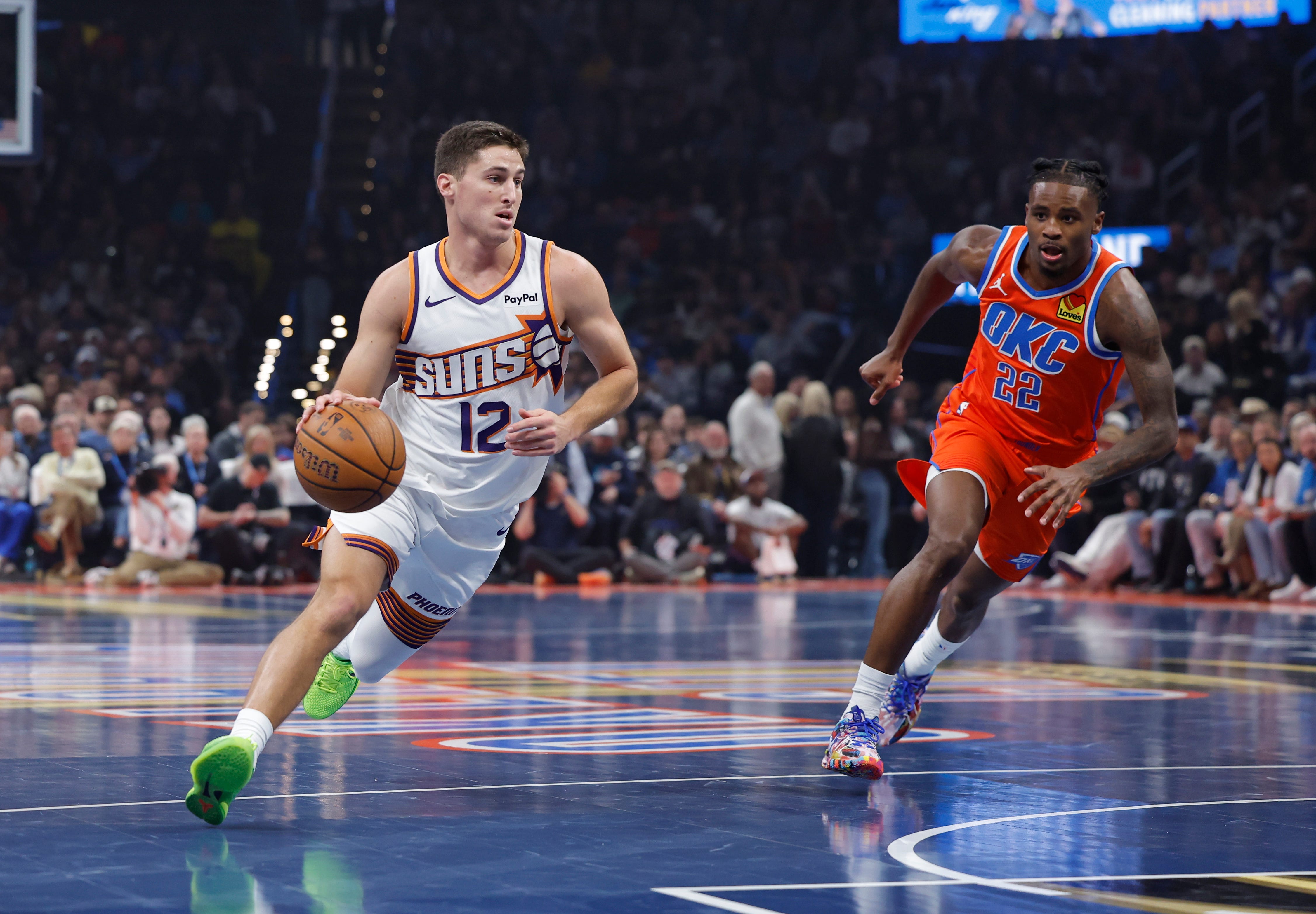 Nov 28, 2025; Oklahoma City, Oklahoma, USA; Phoenix Suns guard Collin Gillespie (12) drives to the basket around Oklahoma City Thunder guard Cason Wallace (22) during the first quarter at Paycom Center. Mandatory Credit: Alonzo Adams-Imagn Images