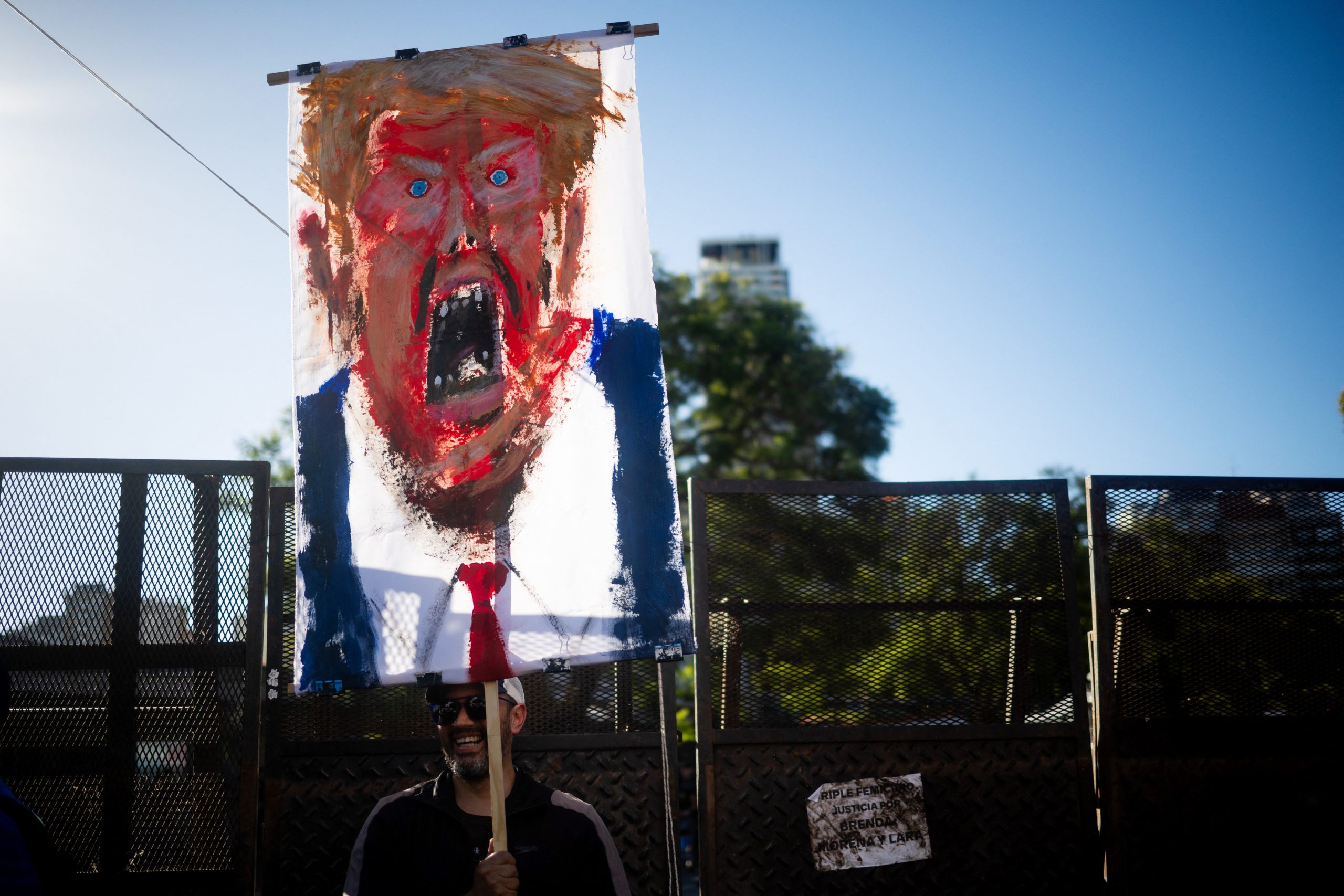 A man holds a painting depicting United States President Donald Trump during a protest against the US intervention in Venezuela, in Buenos Aires on January 5, 2026. Ousted Venezuelan president Nicolas Maduro pleaded not guilty to drug trafficking and other charges in defiant appearance in a New York court on January 5, two days after being snatched by US forces in a stunning raid on his home in Caracas. Photo by Tomas Cuesta/AFP via Getty Images.