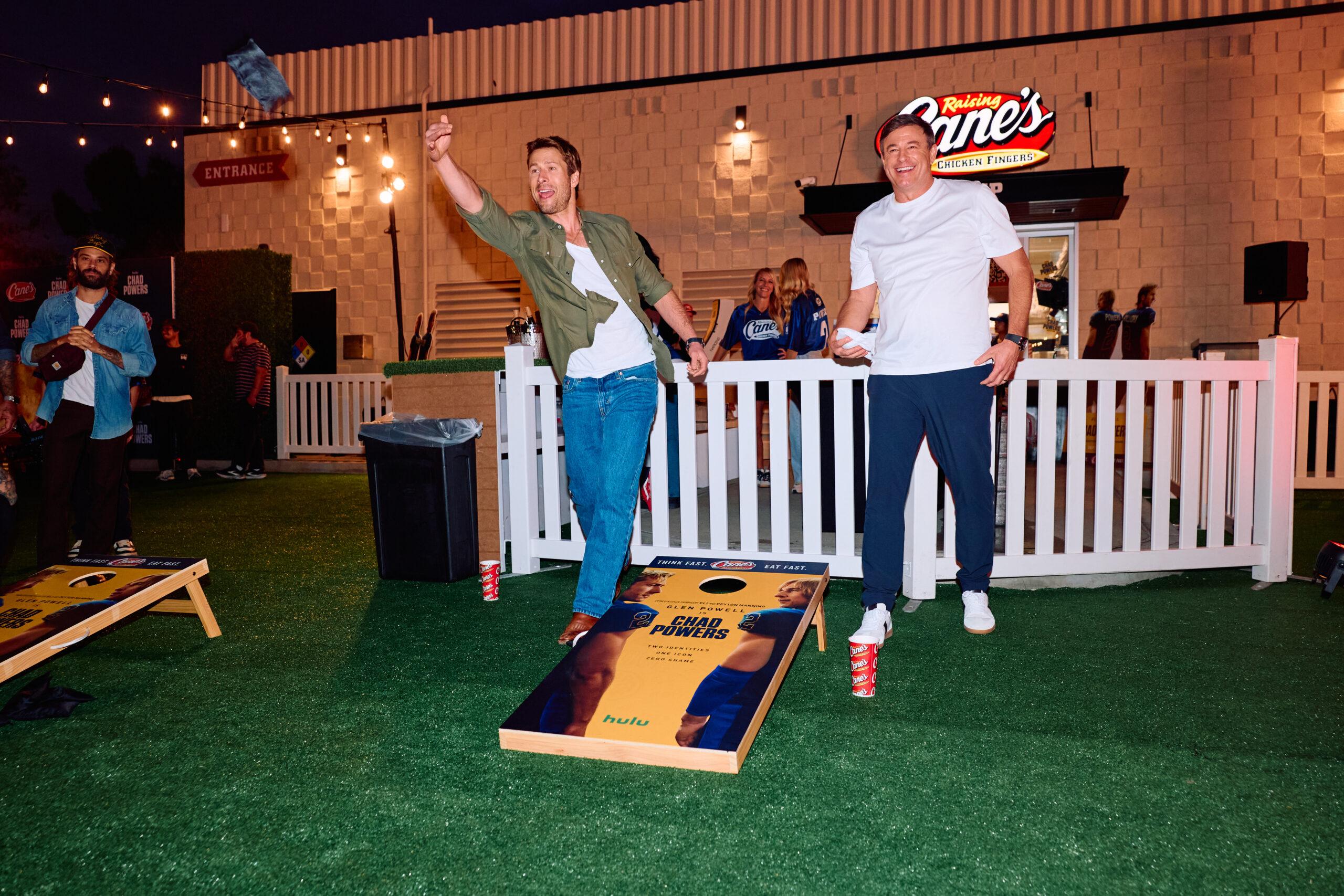 Glen Powell playing cornhole