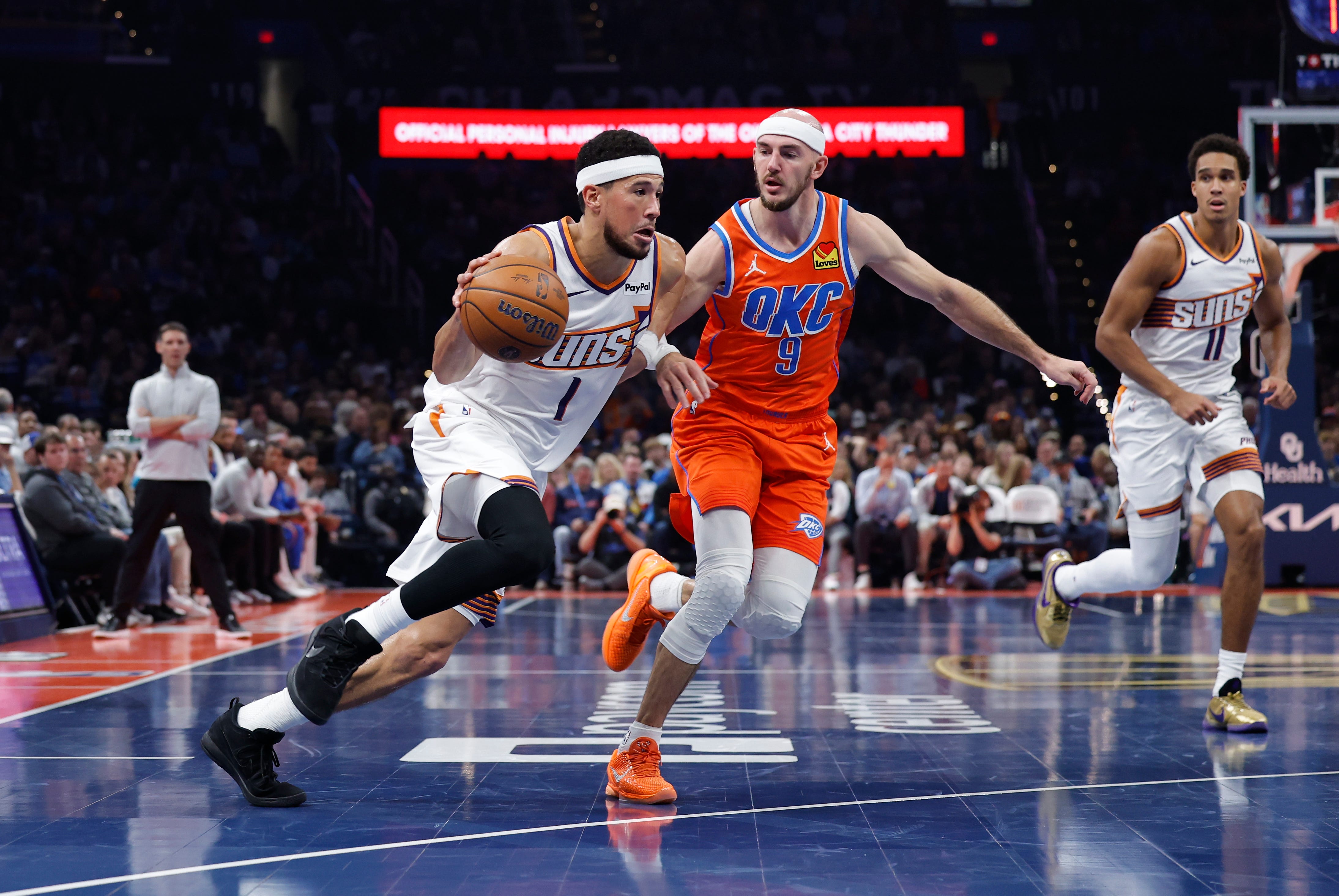 Nov 28, 2025; Oklahoma City, Oklahoma, USA; Phoenix Suns guard Devin Booker (1) drives past Oklahoma City Thunder guard Alex Caruso (9) during the second quarter at Paycom Center. Mandatory Credit: Alonzo Adams-Imagn Images