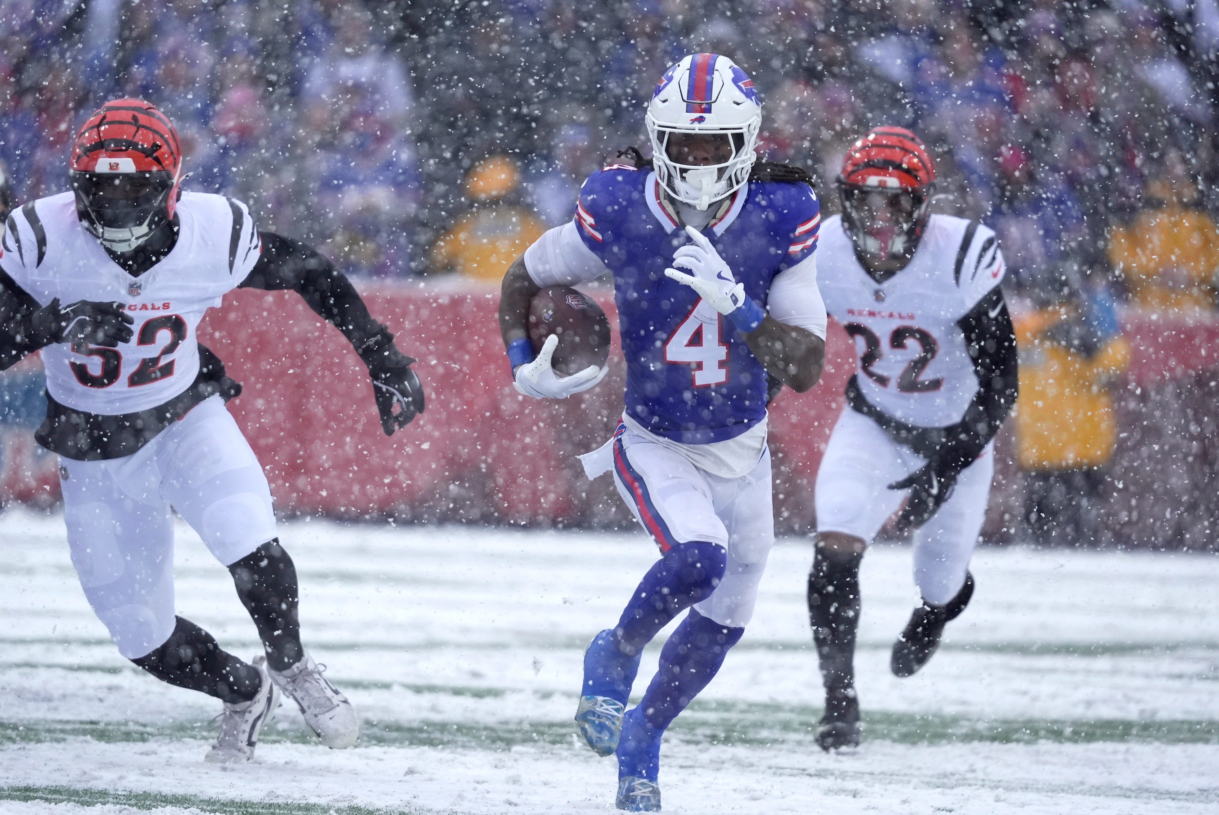 Buffalo Bills running back James Cook III carries the ball getting past Cincinnati Bengals running back Gary Brightwell and safety Geno Stone during first half action at Highmark Stadium in Orchard Park on Dec. 7, 2025
