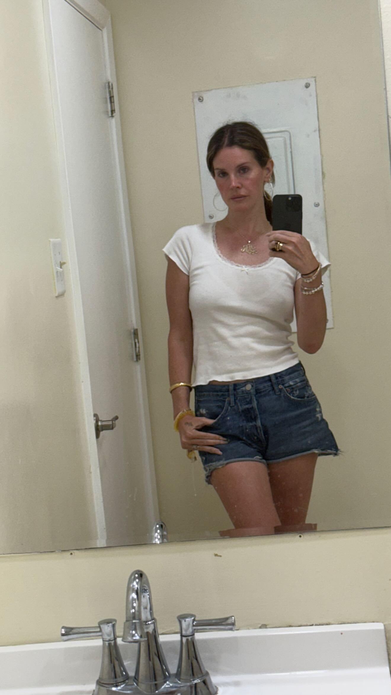 Lana Del Rey poses in front of a mirror