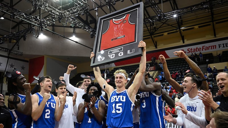 BYU guard Richie Saunders (15) raises a framed jersey after being named the tournament MVP after his team's win over Dayton in an NCAA college basketball game, Friday, Nov. 28, 2025, in Kissimmee, Fla.