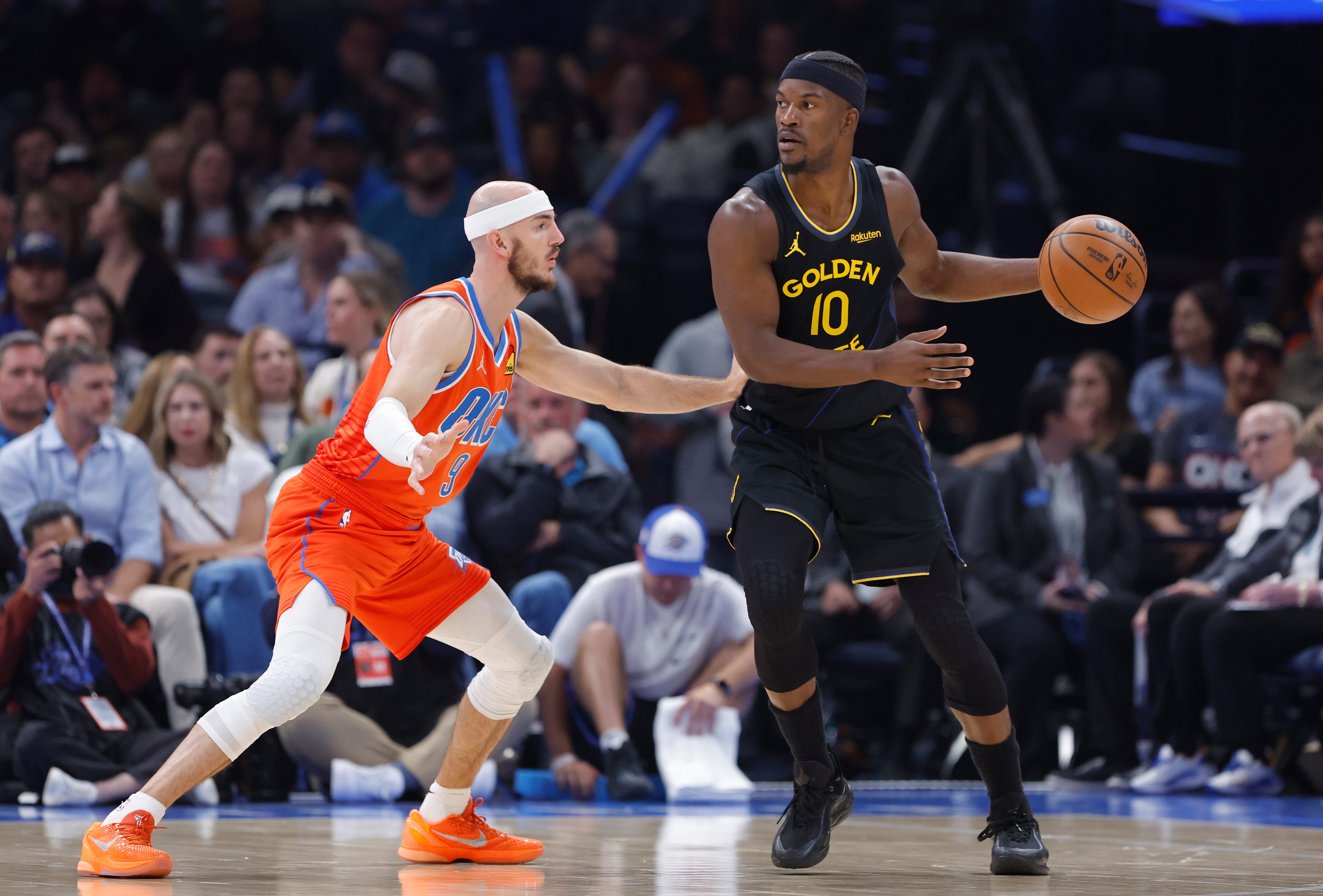 Nov 11, 2025; Oklahoma City, Oklahoma, USA; Golden State Warriors forward Jimmy Butler III (10) moves the ball across the court as Oklahoma City Thunder guard Alex Caruso (9) defends during the second quarter at Paycom Center. Mandatory Credit: Alonzo Adams-Imagn Images