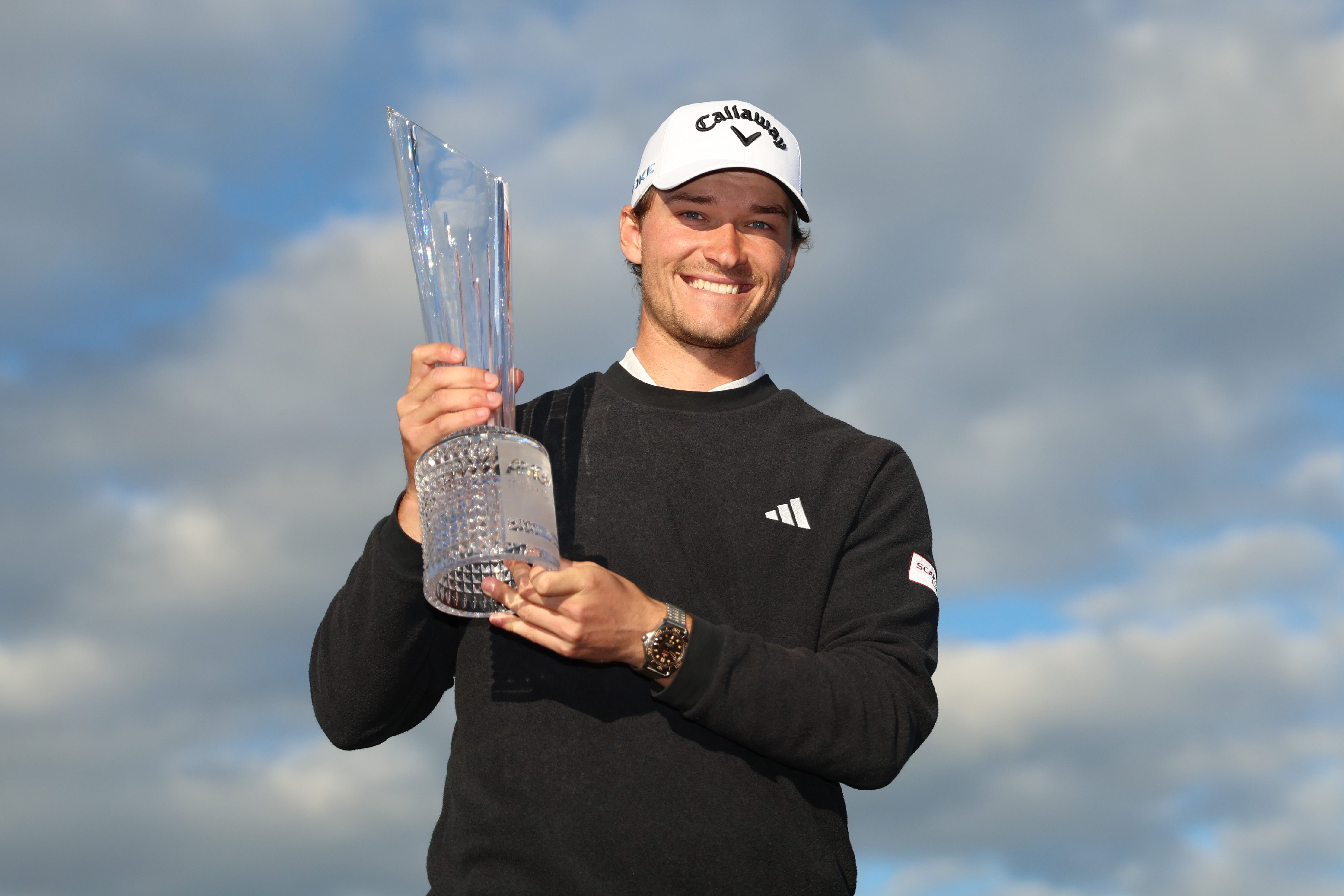 NEWCASTLE, NORTHERN IRELAND - SEPTEMBER 15: Rasmus Hojgaard of Denmark poses for a photo as he celebrates with the trophy on the 18th green after winning during day four of the Amgen Irish Open 2024 at Royal County Down Golf Club on September 15, 2024 in Newcastle, Northern Ireland. (Photo by Luke Walker/Getty Images)