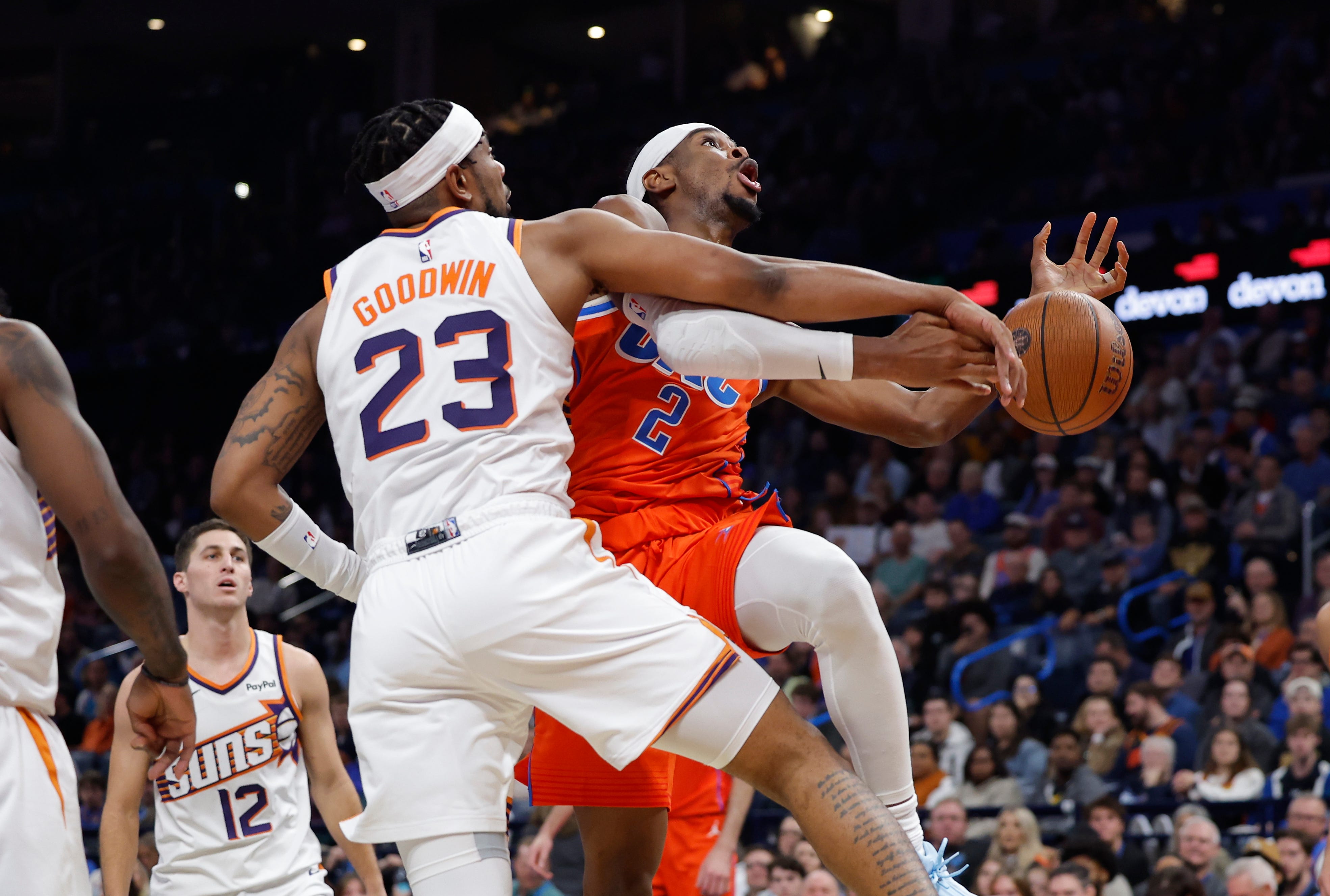 Nov 28, 2025; Oklahoma City, Oklahoma, USA; Phoenix Suns guard Jordan Goodwin (23) fouls Oklahoma City Thunder guard Shai Gilgeous-Alexander (2) on the to the basket during the second half at Paycom Center. Mandatory Credit: Alonzo Adams-Imagn Images