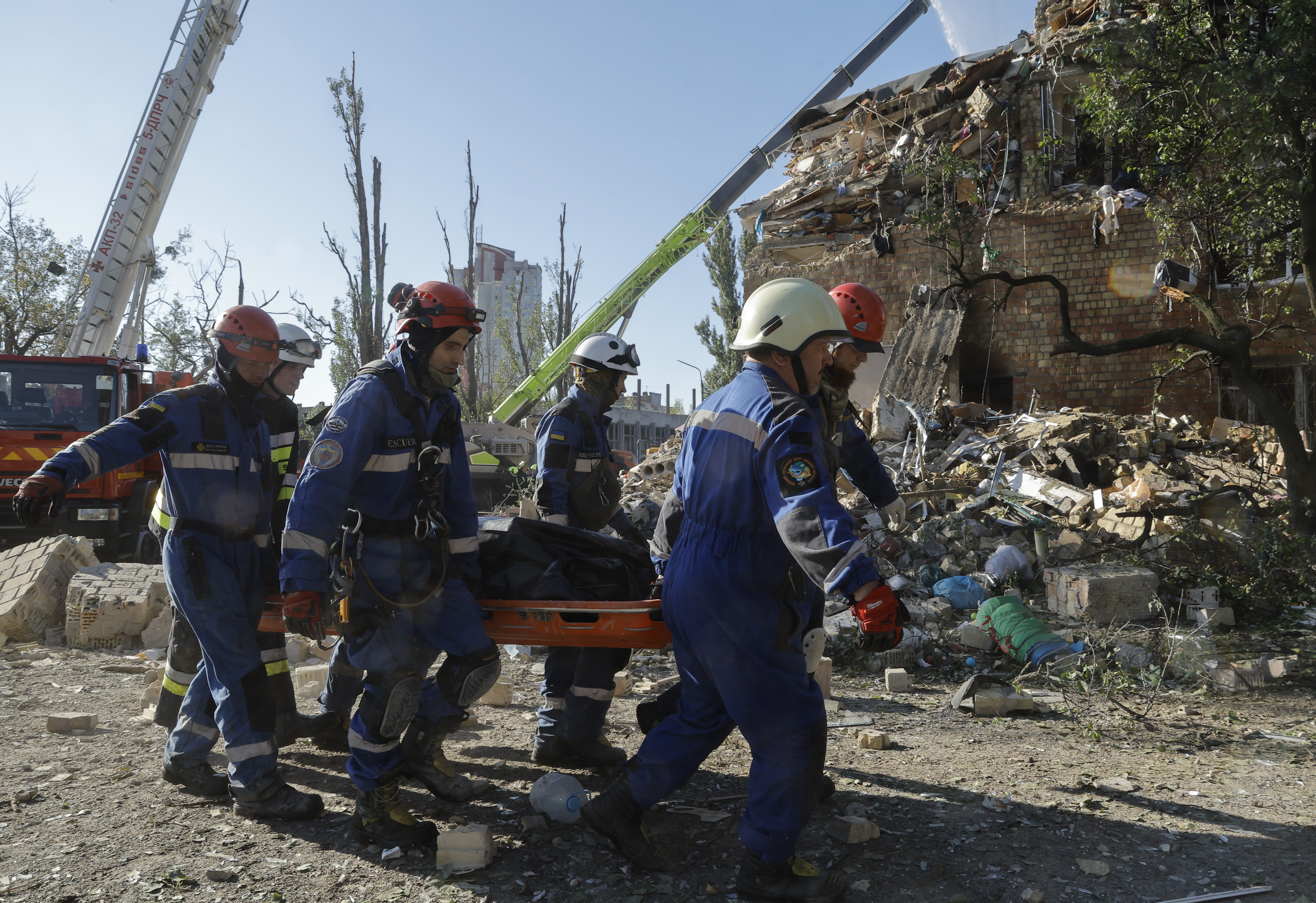 epa12328961 Ukrainian rescuers carry the body of a victim at the site of a Russian strike on a five-storey residential building in Kyiv, Ukraine, 28 August 2025, amid the ongoing Russian invasion. At least 14 people were killed, including 3 children, and 38 were injured in Kyiv, as Russia launched an overnight attack over Ukraine with 598 drones and 31 missiles, according to the State Emergency Service. EPA/SERGEY DOLZHENKO