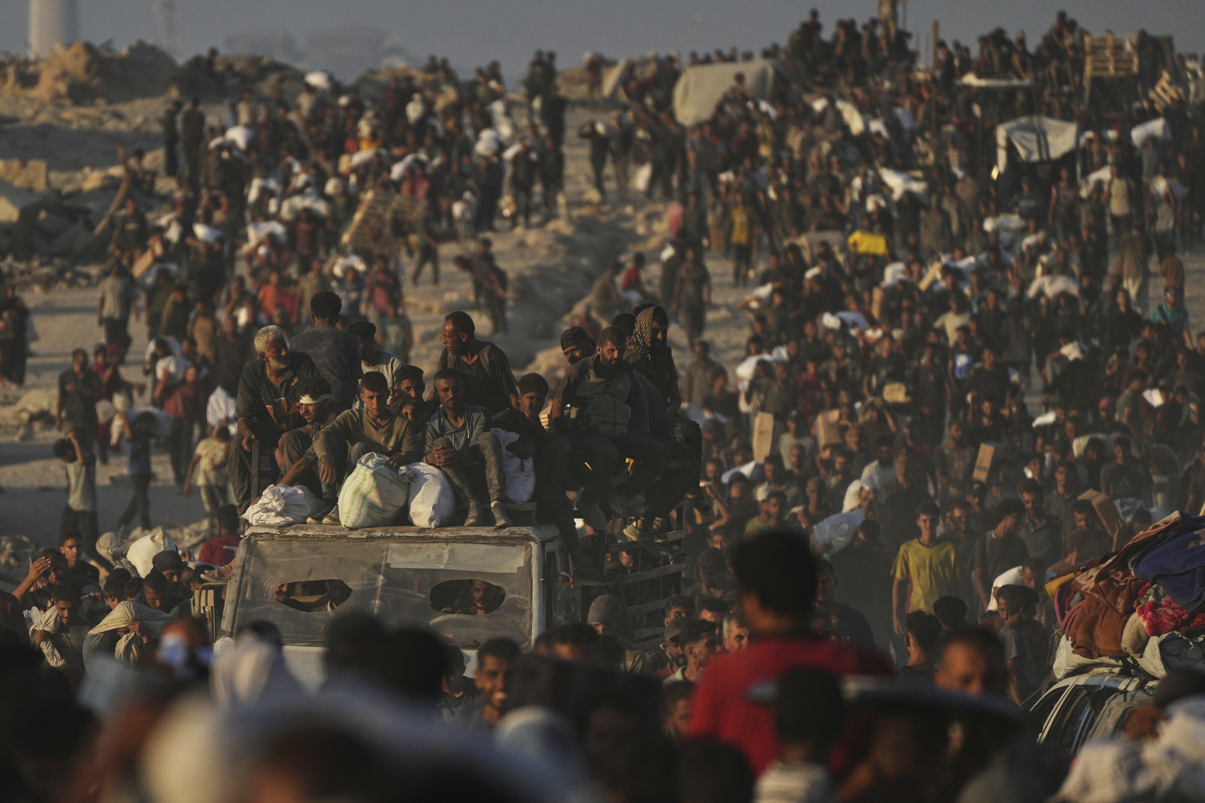 Palestinians carry sacks of flour unloaded from a humanitarian aid convoy that reached Gaza City from the northern Gaza Strip, Sunday, Aug. 24, 2025. (AP Photo/Abdel Kareem Hana)