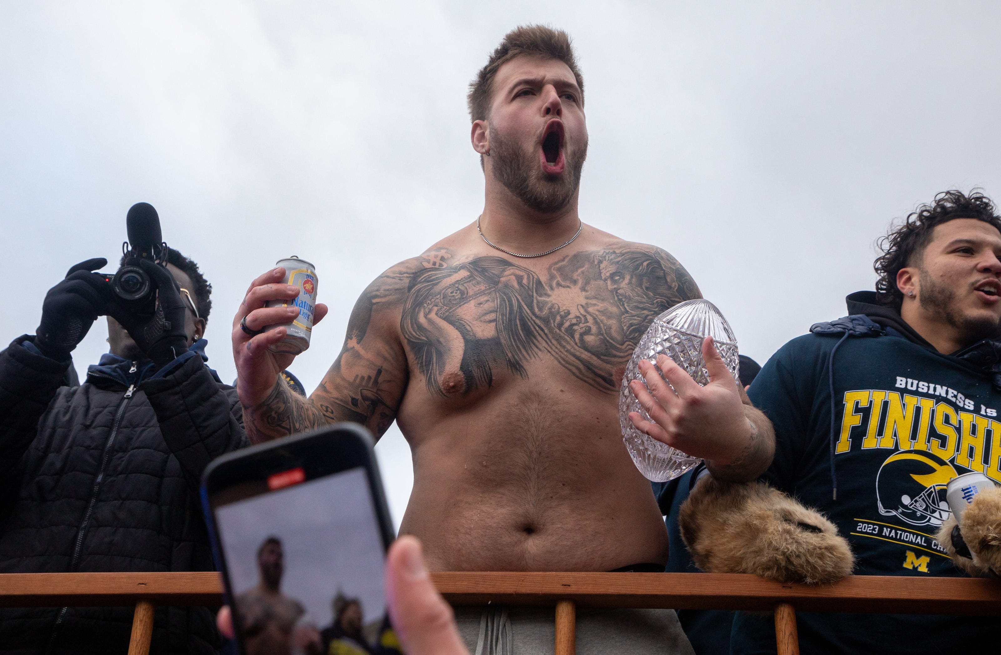 Michigan&acirc;&euro;&trade;s Trevor Keegan holds a beer in one hand and the 2023 National Championship trophy in the other during a parade at the University of Michigan campus in Ann Arbor on Saturday, Jan. 13, 2024.