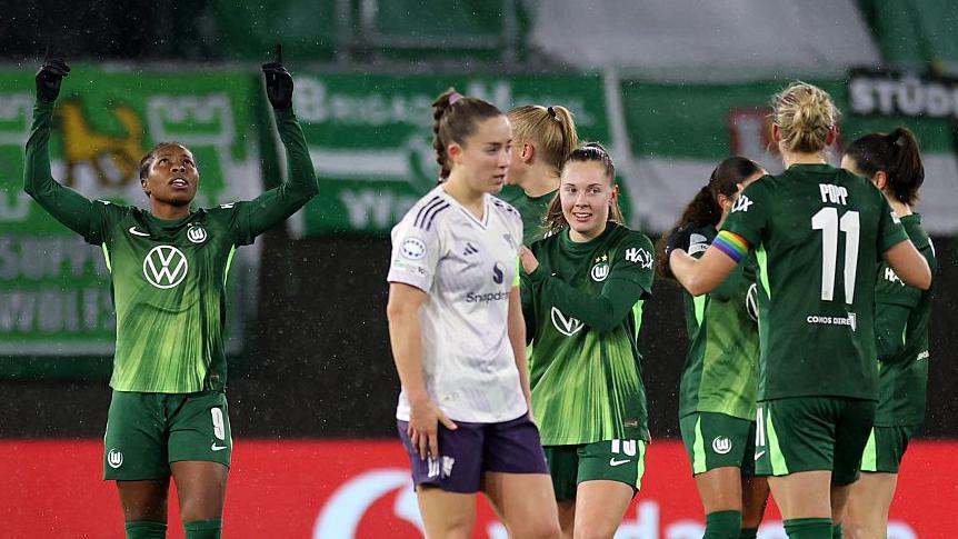 Maya Le Tissier looks dejected as Wolfsburg players celebrate scoring a goal in the background