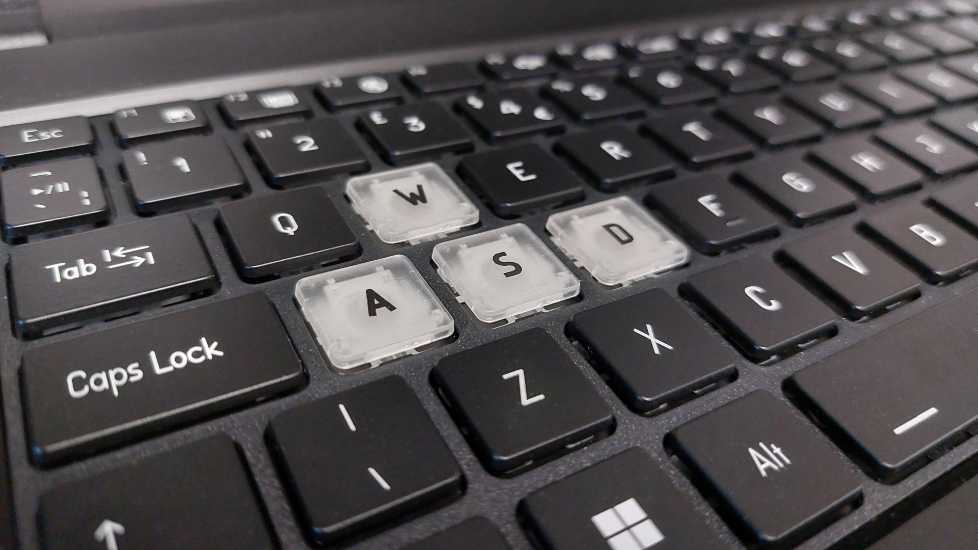 The Erazer Scout 15 E1 RTX 5050 gaming laptop is seen on a wooden desk in a brightly lit, neutral toned office.