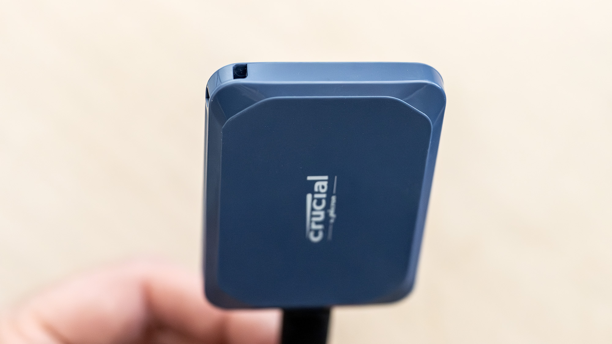 A Crucial X10 external SSD in blue with USB Type-C connector cable.